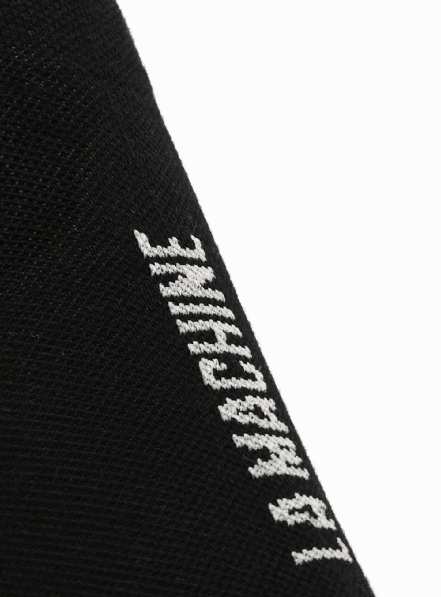 Close-up of black La Machine Cycle Club Logo Cycling Socks in Merino, featuring vertically oriented white text—these unisex performance socks offer comfort across all seasons.