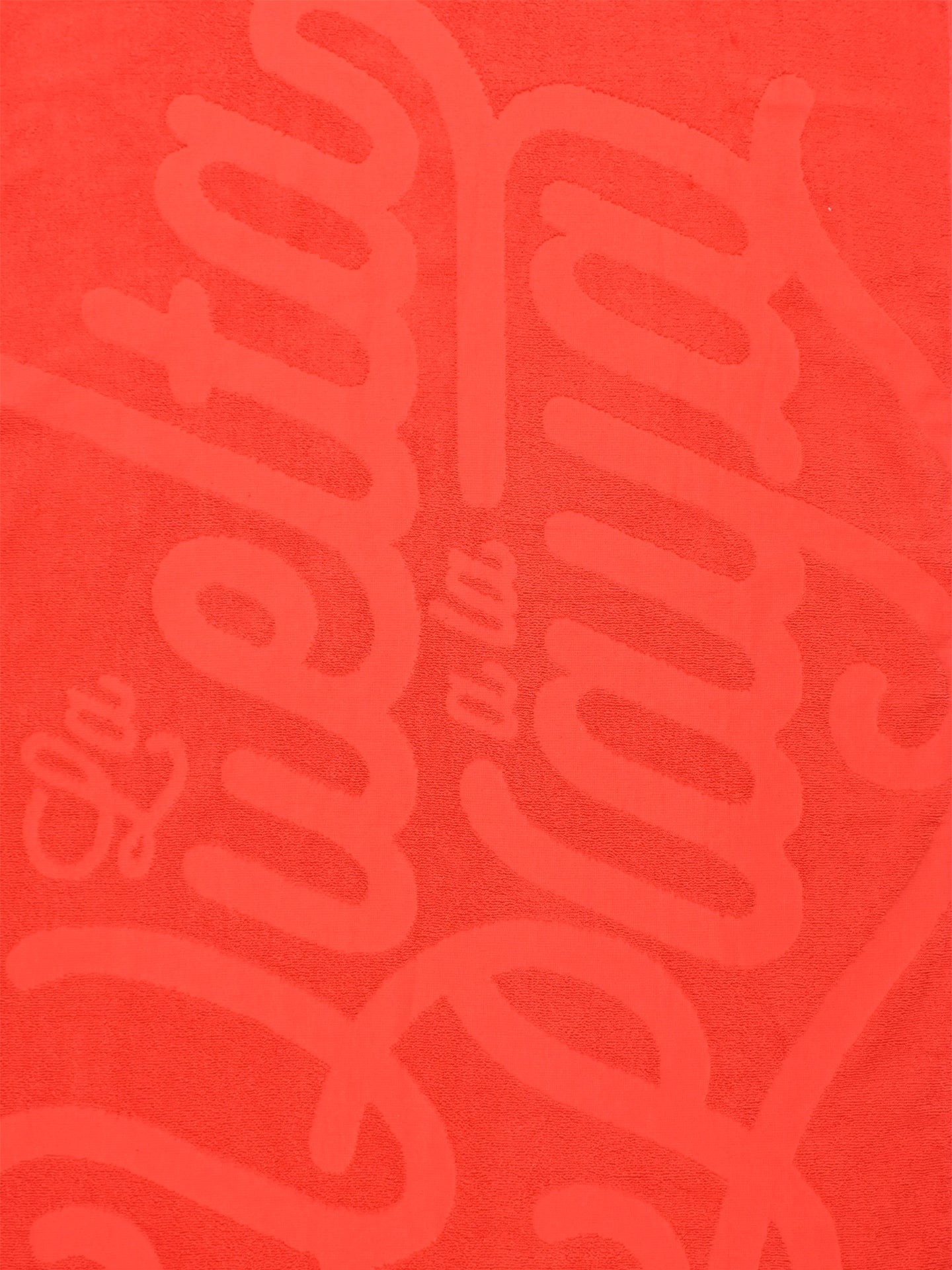 The La Vuelta a la Playa - Beach Towel by La Machine Cycle Club is a premium red cotton towel featuring bold, stylized La Vuelta a la Playa lettering—ideal for cycling fans who value comfort and style at the beach.