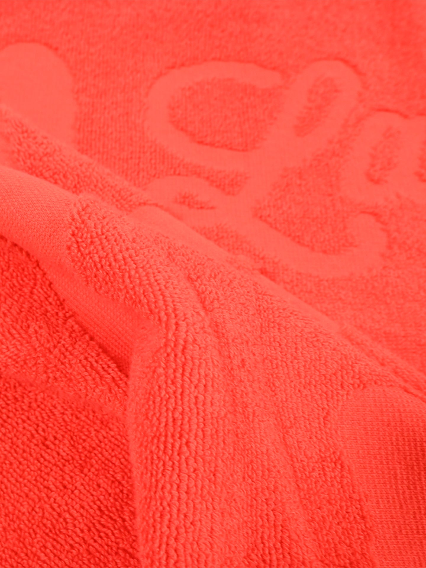 Close-up of La Vuelta a la Playa Beach Towel by La Machine Cycle Club, highlighting its soft, premium cotton, textured surface with embossed patterns and visible folds in the fabric.