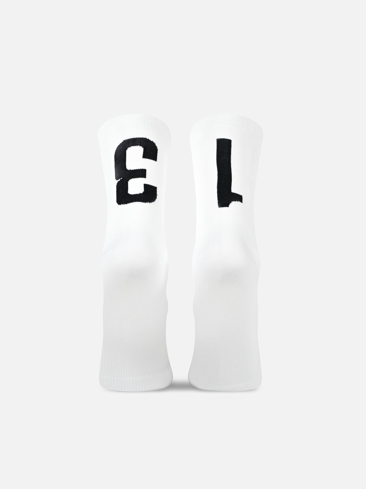 La Machine Cycle Club’s Bib Number 13 - Cycling Socks in white feature bold black “1” and “3” on the front, a seamless toe, and are shown upright side by side against a plain background.