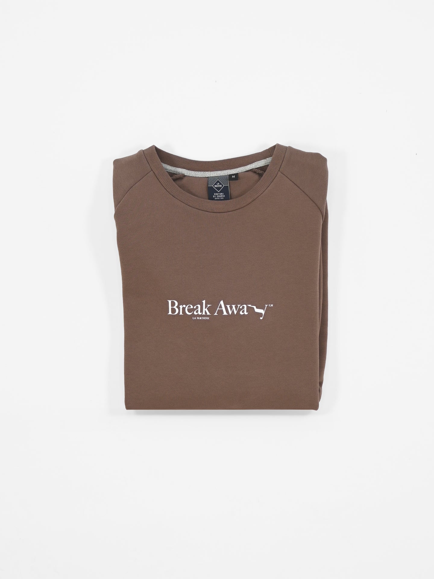 A folded brown La Machine Cycle Club Break Away sweatshirt, featuring white Break Away text and a small running animal graphic on the front, is displayed on a white background—ideal for cycling enthusiasts.