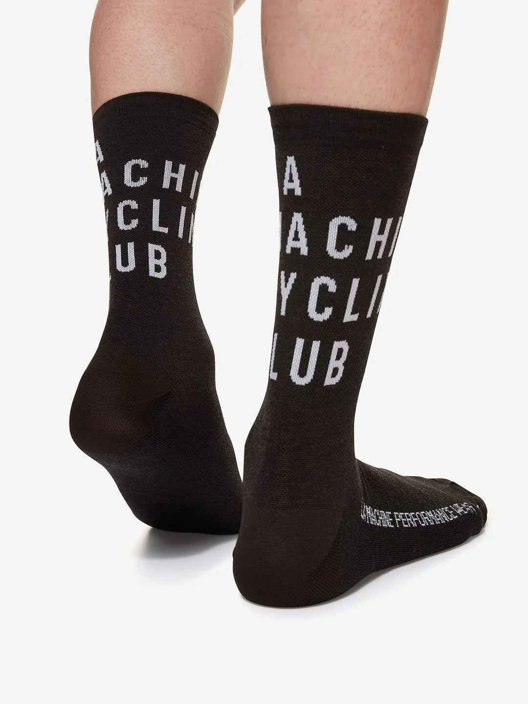 A person wearing La Machine Cycle Clubs LMCC - Cycling Socks - Bundle is shown from behind, both feet visible on a white surface, featuring high-profile unisex socks with CYCLING CLUB text on the back.