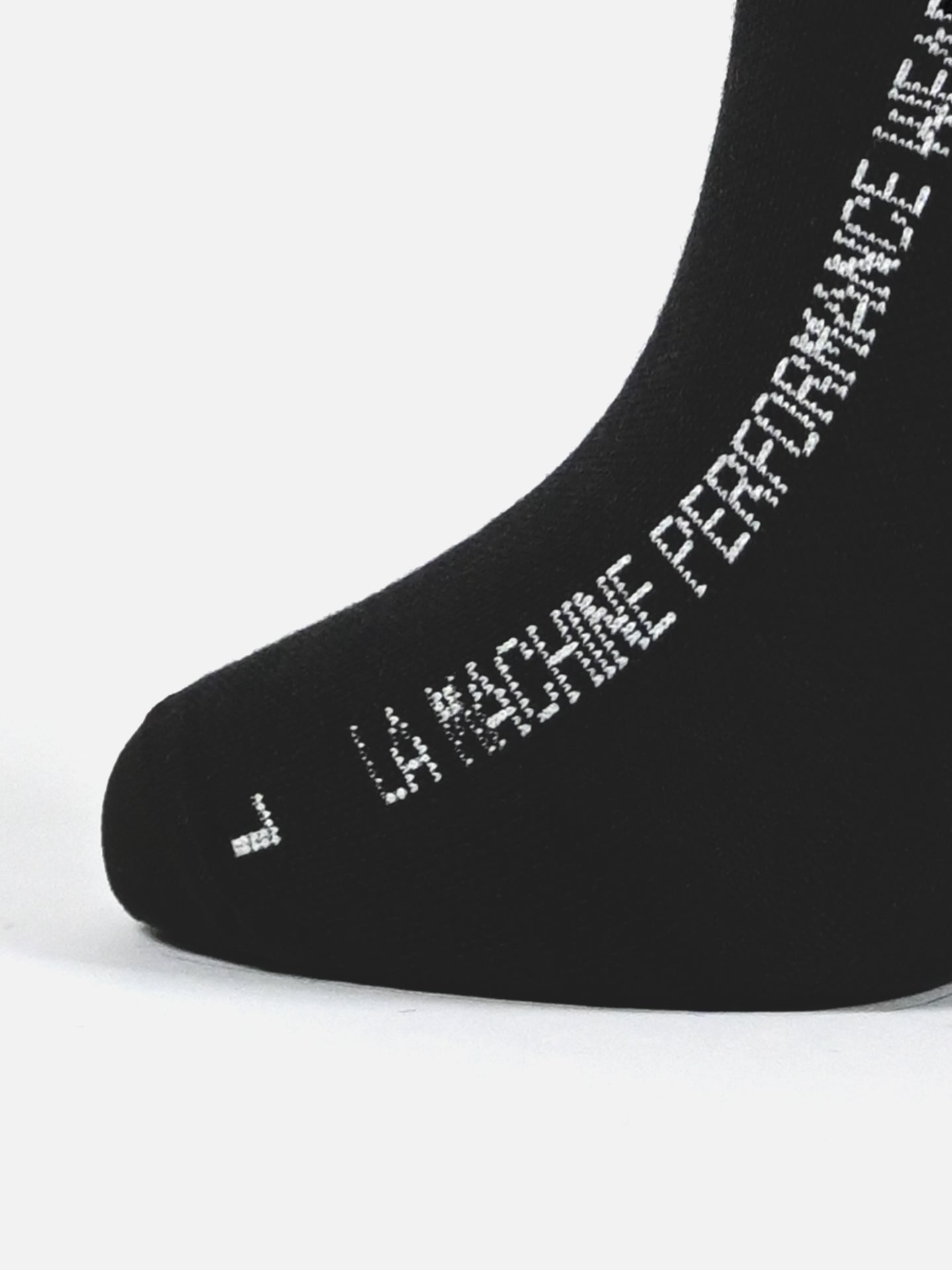 Close-up of the toe and side of a black unisex LMCC - Cycling Socks - Merino by La Machine Cycle Club, featuring white “LA MACHINE PERFORMANCE WE” text along the foot.