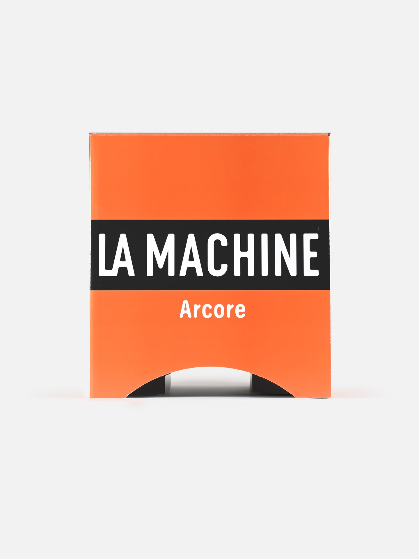 An orange rectangular box with a black stripe reading LA MACHINE and Arcore below doubles as the Molteni - 2-in-1 Stool & Sidetable by La Machine Cycle Club, serving as unique foldable cardboard furniture.