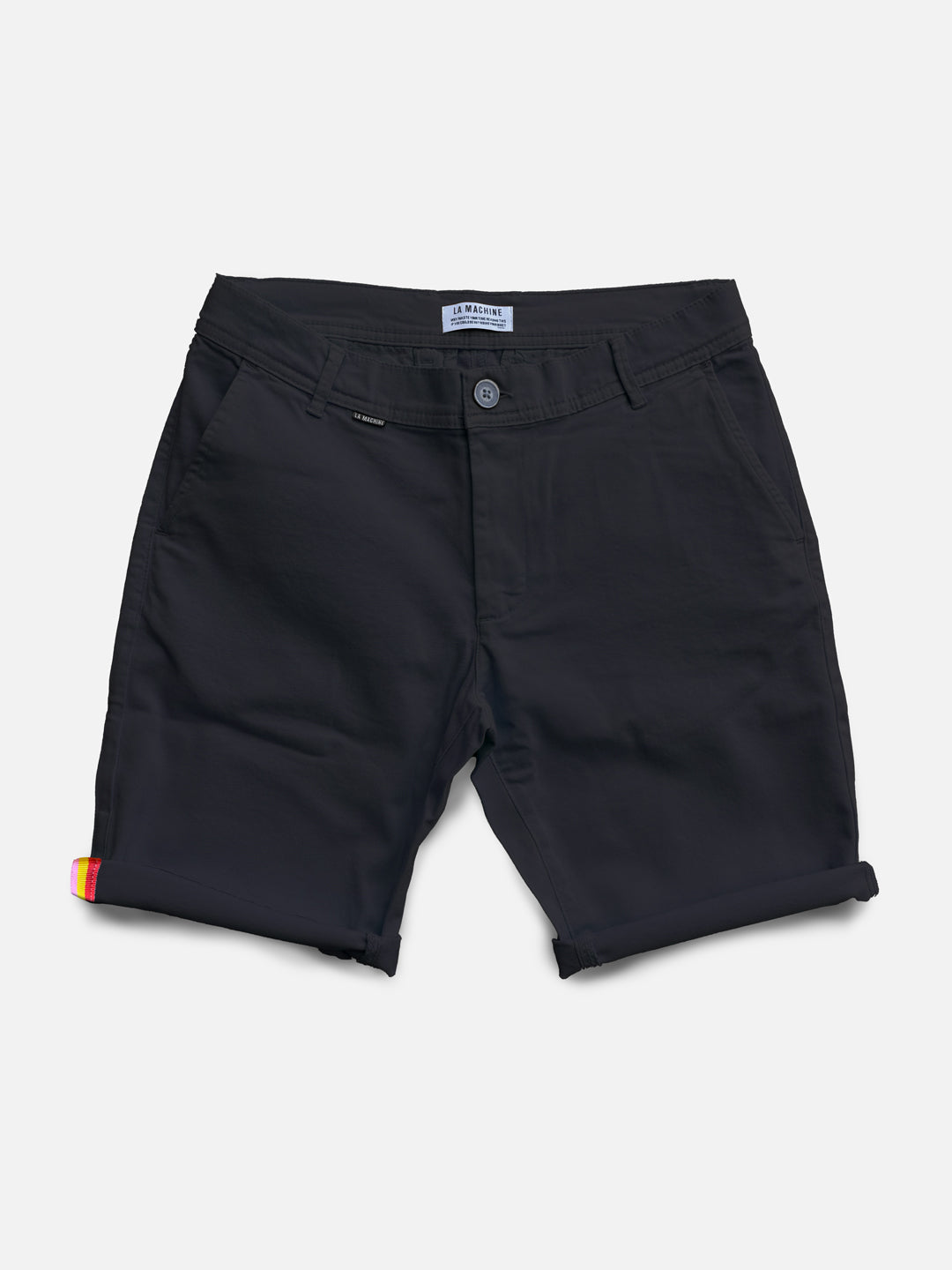 The Grand Tours - Rest Day Bermuda by La Machine Cycle Club is a pair of navy men’s chino shorts with a semi-tailored fit, rolled cuffs, button and zip closure, side pockets, Grand Tour tape lining, and a colorful tag on the left cuff.