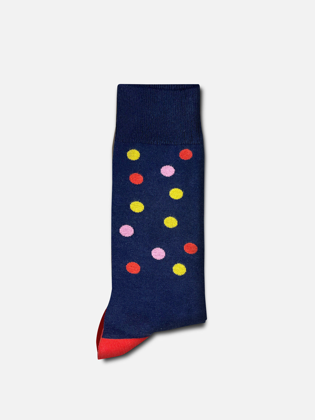 A single Grand Tours - Dots casual sock by La Machine Cycle Club, unisex, navy blue with pink, yellow, and red polka dots and a red toe, shown flat on a light gray background.