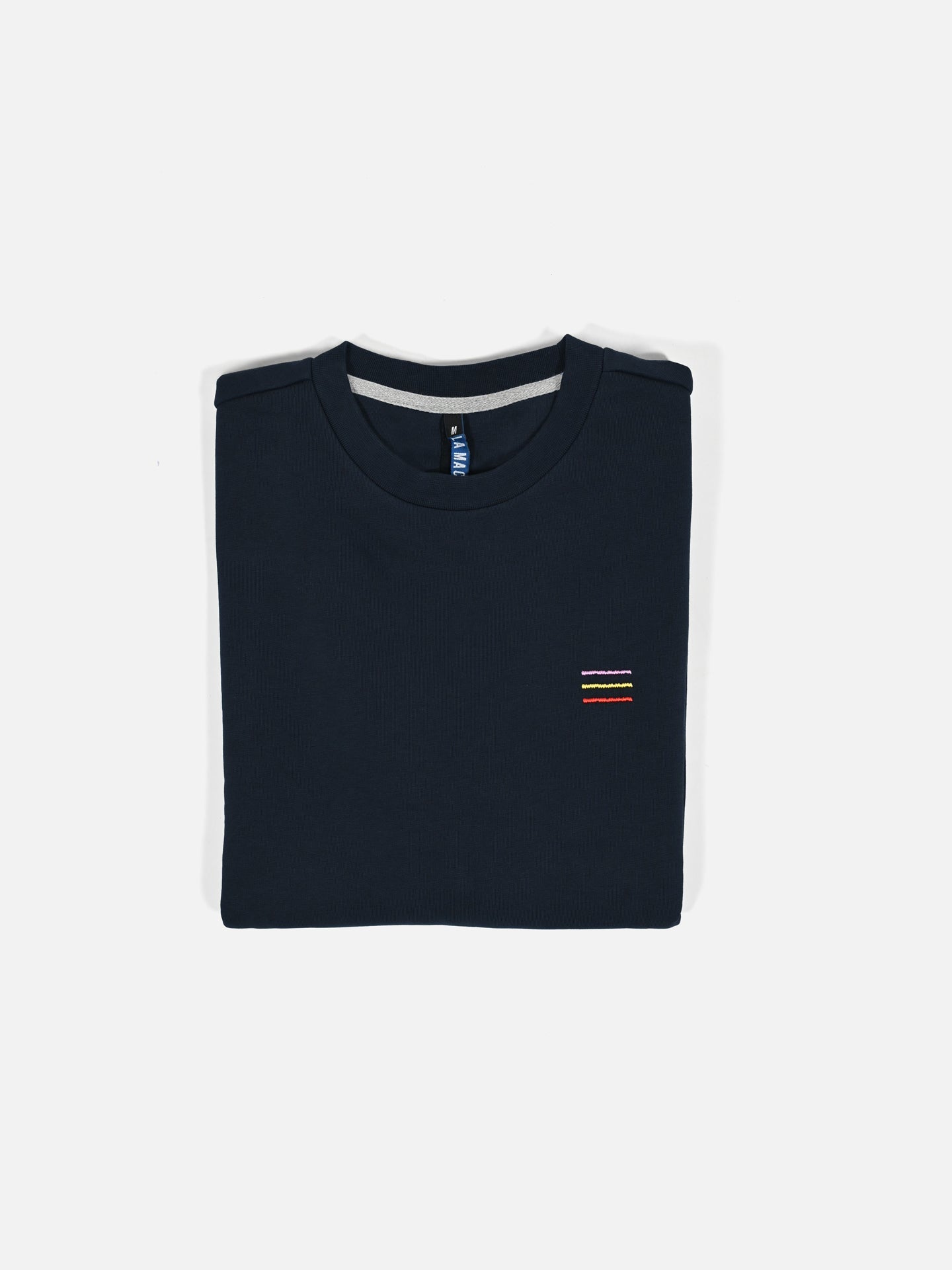 The Grand Tours III - Embroidered Sweatshirt by La Machine Cycle Club features subtle horizontal embroidery on the left chest and is neatly folded in navy blue, displayed against a plain white background.