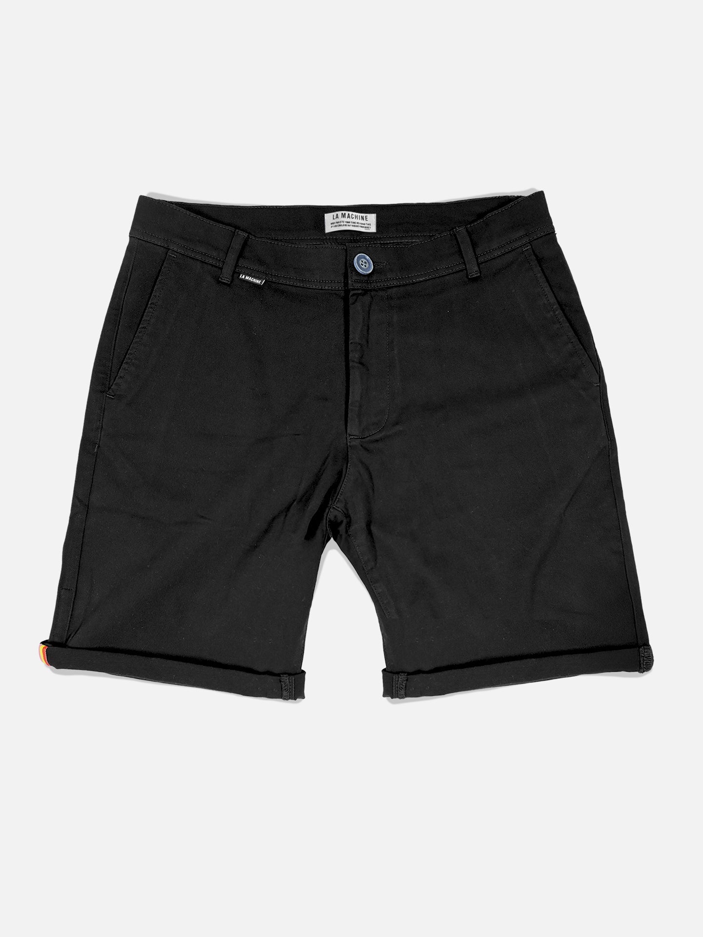 La Machine Cycle Clubs Grand Tours - Rest Day Bermuda in black features a semi-tailored fit, front pockets, belt loops, and a button closure, with slightly rolled hems for a classic look. Shorts shown laid flat on a white background.