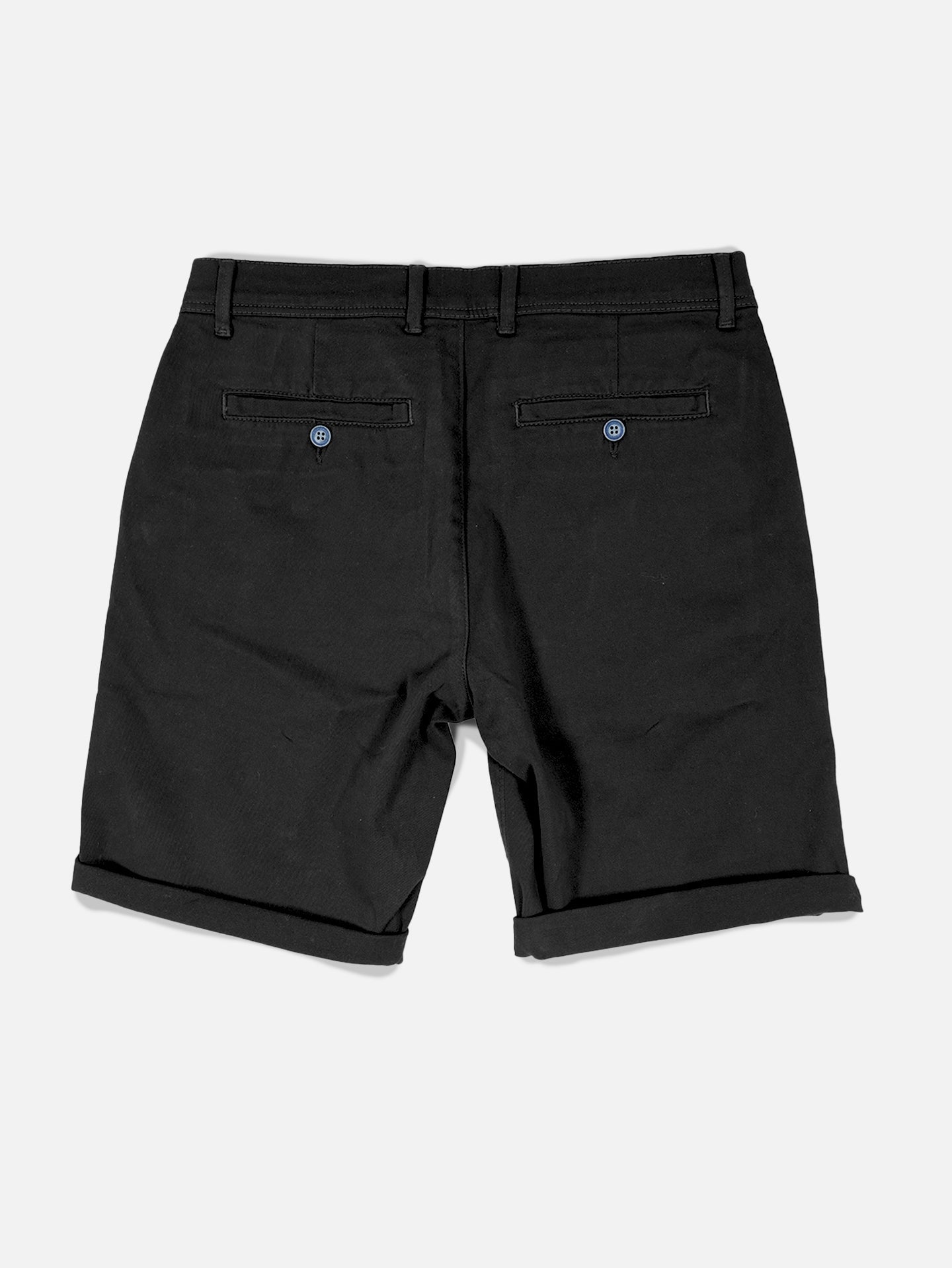 The Grand Tours - Rest Day Bermuda in black by La Machine Cycle Club is shown flat from the back on a white background, featuring belt loops, two buttoned back pockets, cuffed hems, and a semi-tailored fit.