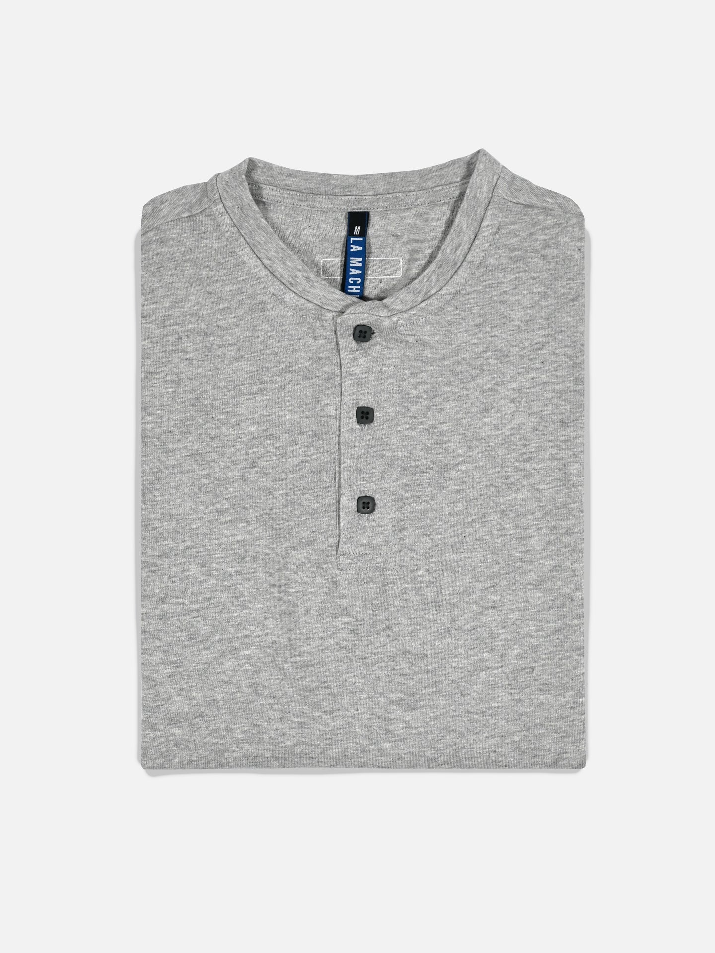 The Le Pavé Henley in Light Cobble Grey by La Machine Cycle Club is a heavy cotton long sleeve shirt with three black front buttons, neatly folded and displayed against a plain white background.