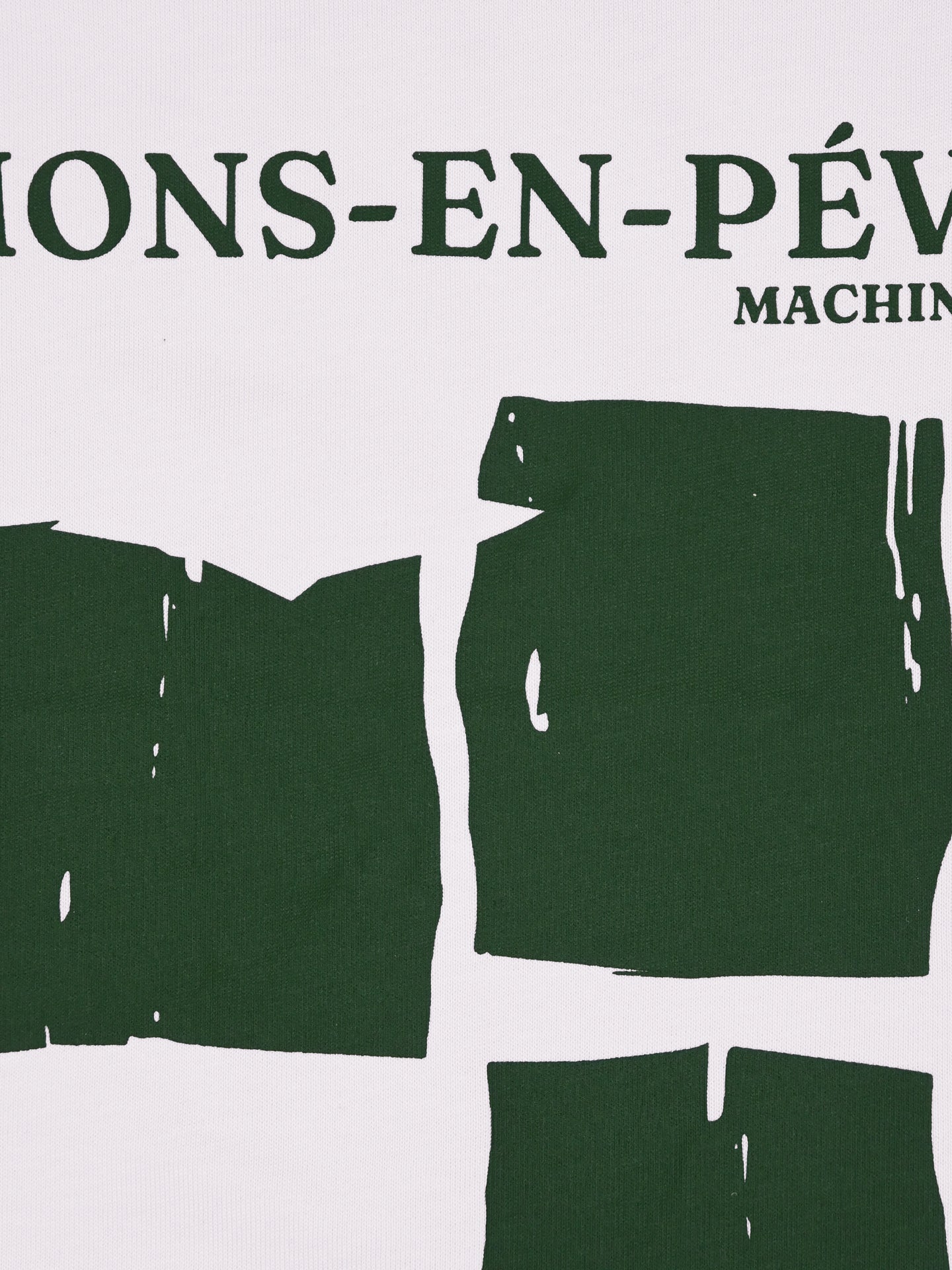 A close-up of La Machine Cycle Clubs Made in Mons-en-Pévèle - Loose Fit - T-shirt shows white cycling fabric with dark green text and abstract shapes, featuring partial letters that nod to the legendary Paris-Roubaix sector.