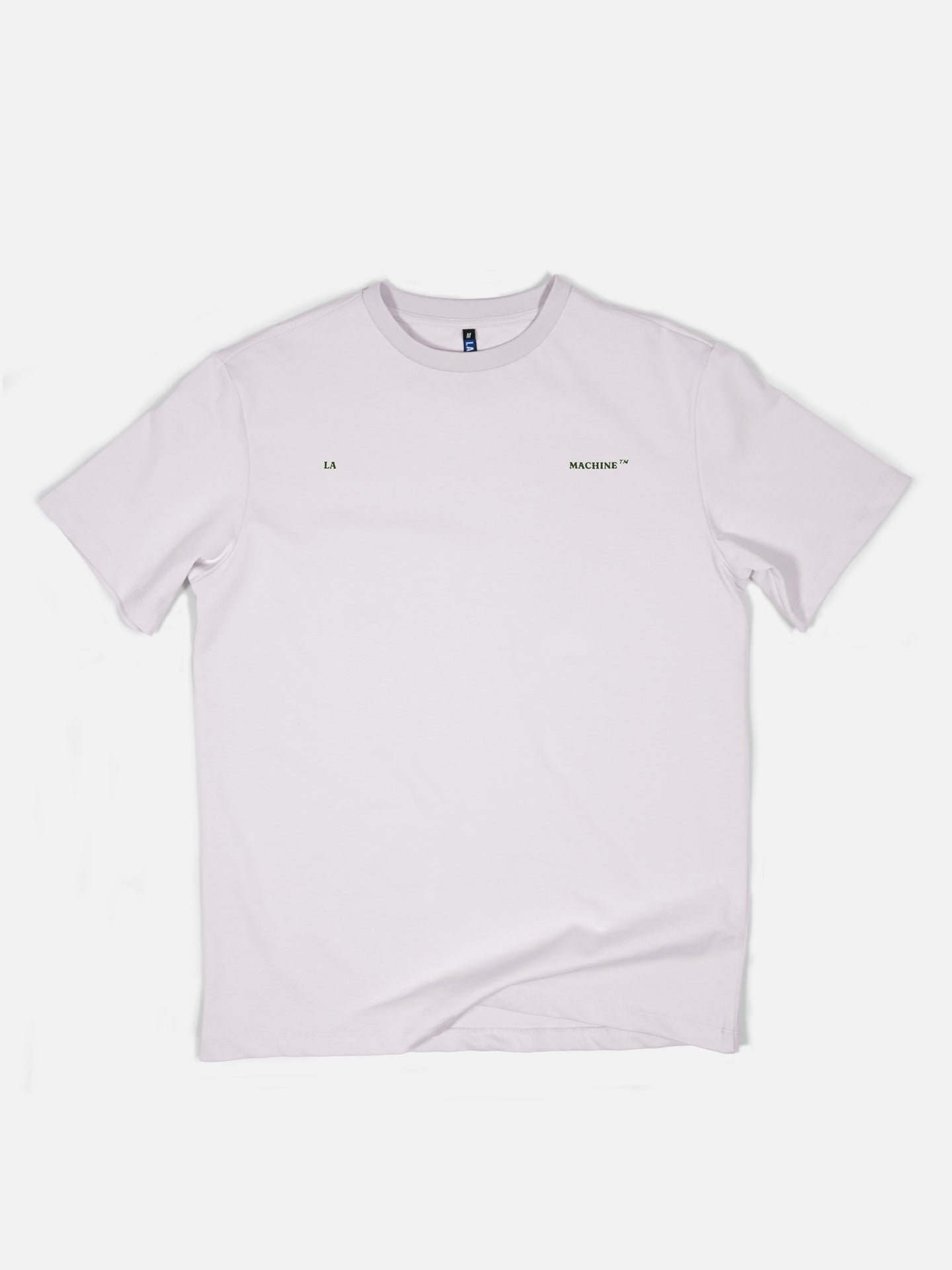 The Made in Mons-en-Pévèle - Loose Fit T-shirt by La Machine Cycle Club is a plain white short-sleeve tee with small black LA MACHINE™ chest text, inspired by iconic cycling apparel and Paris-Roubaix. Shirt shown flat on a white background.