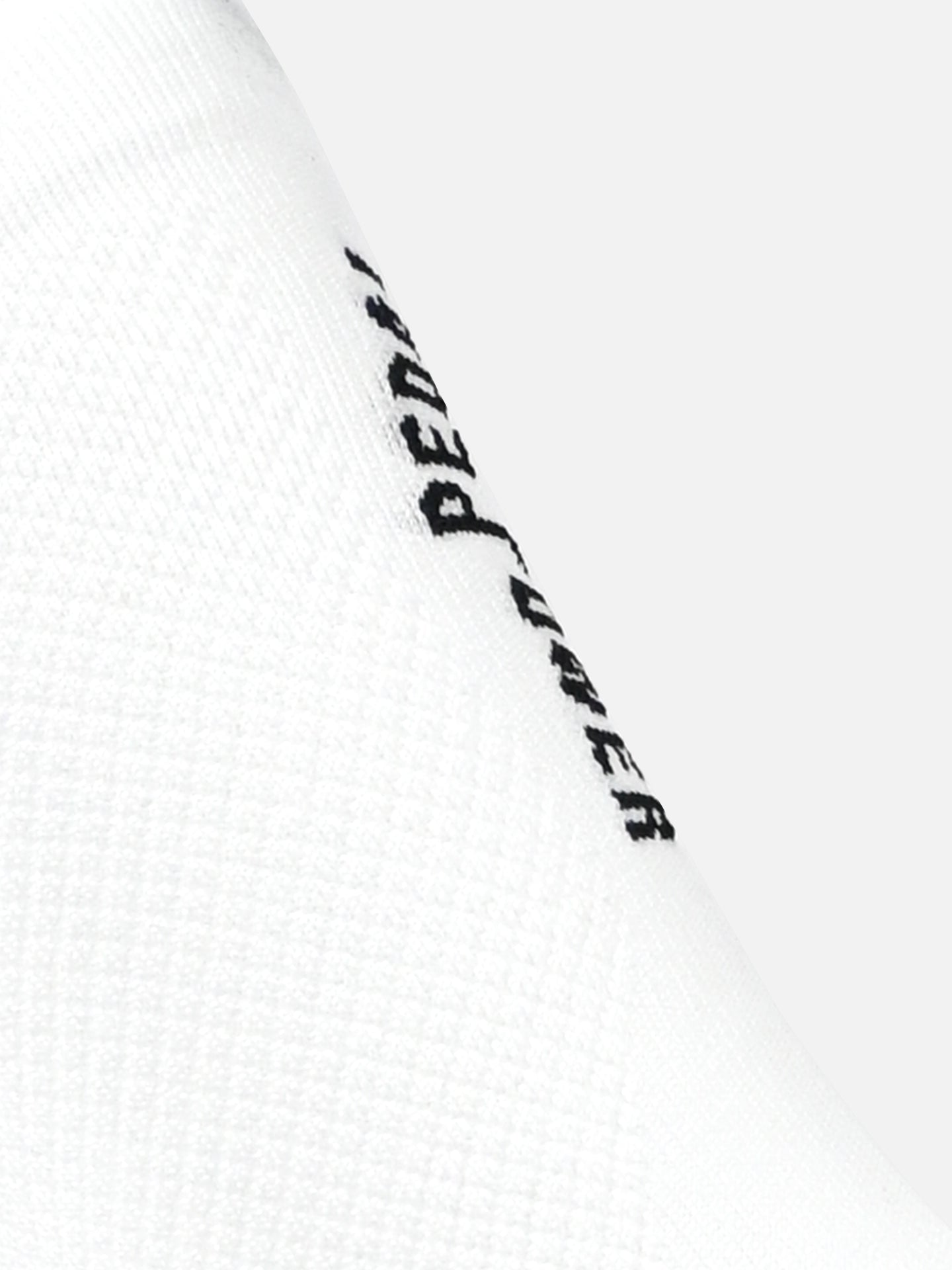 Close-up of La Machine Cycle Clubs Pedal Power - Cycling Socks in white, showing the seamless toe construction and black PEDAL text on the textured fabric, set against a plain light gray background.