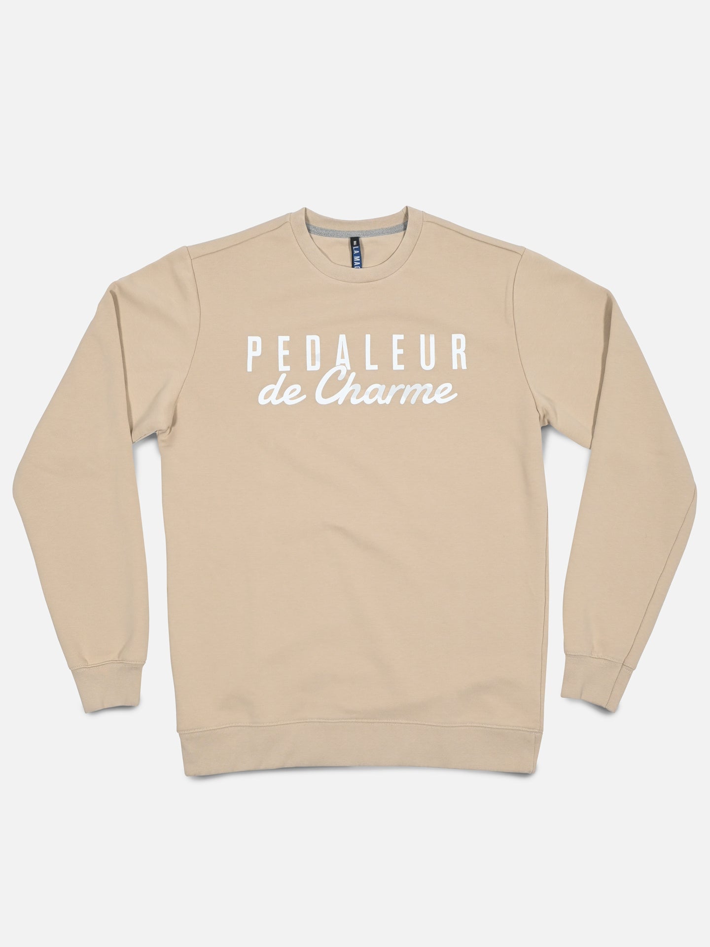 The La Machine Cycle Club “Pedaleur de Charme - Sweatshirt - Sand” is a beige men’s premium sweatshirt featuring “PEDALEUR de Charme” in white on the front, inspired by Hugo Koblet and shown flat on a white background.