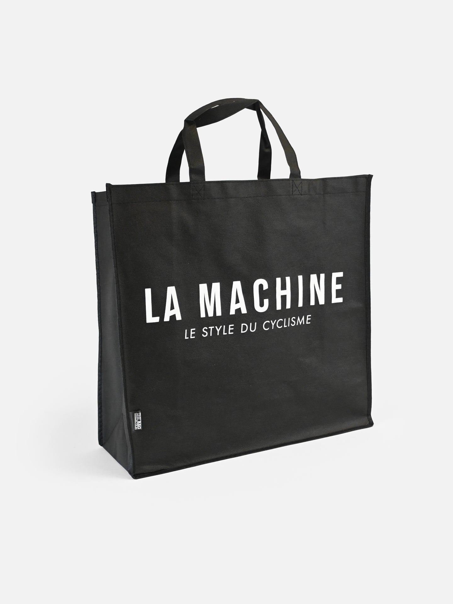 The La Machine - Shopper by La Machine Cycle Club is a large black non-woven tote with two handles, featuring the white La Machine logo and LE STYLE DU CYCLISME—a stylish cycling bag for daily use.