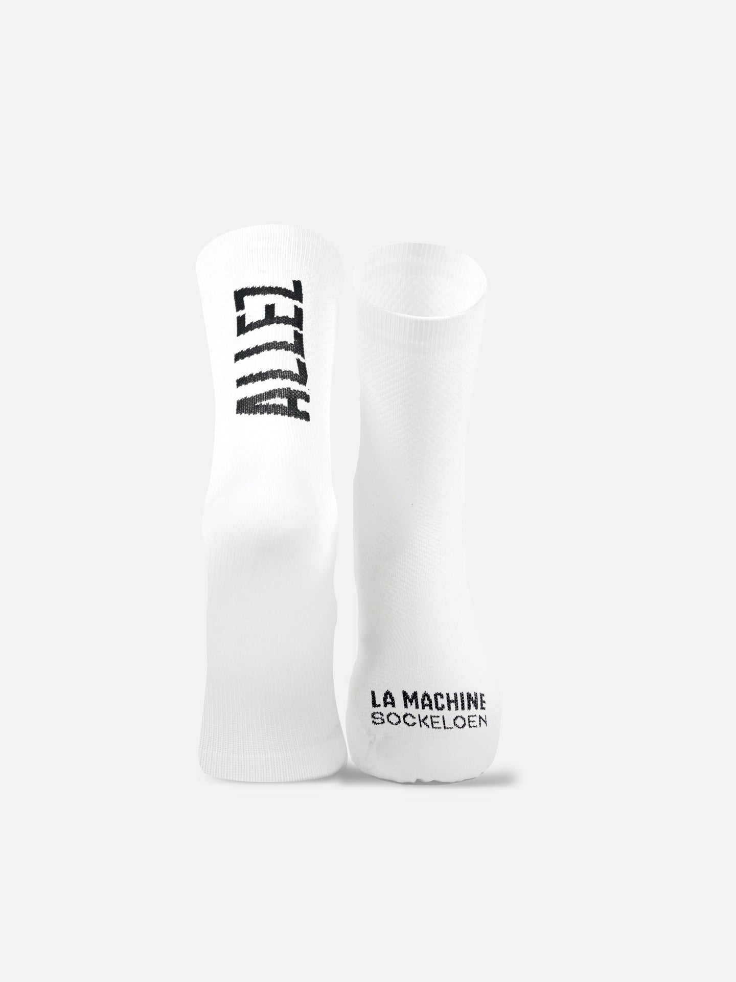 Two all-white Allez Allez - Cycling Socks by La Machine Cycle Club stand upright on a light gray background. One sock features ALLEZ in bold black lettering; the other has LA MACHINE SOCKELOEN near the seamless toe for a perfect fit.