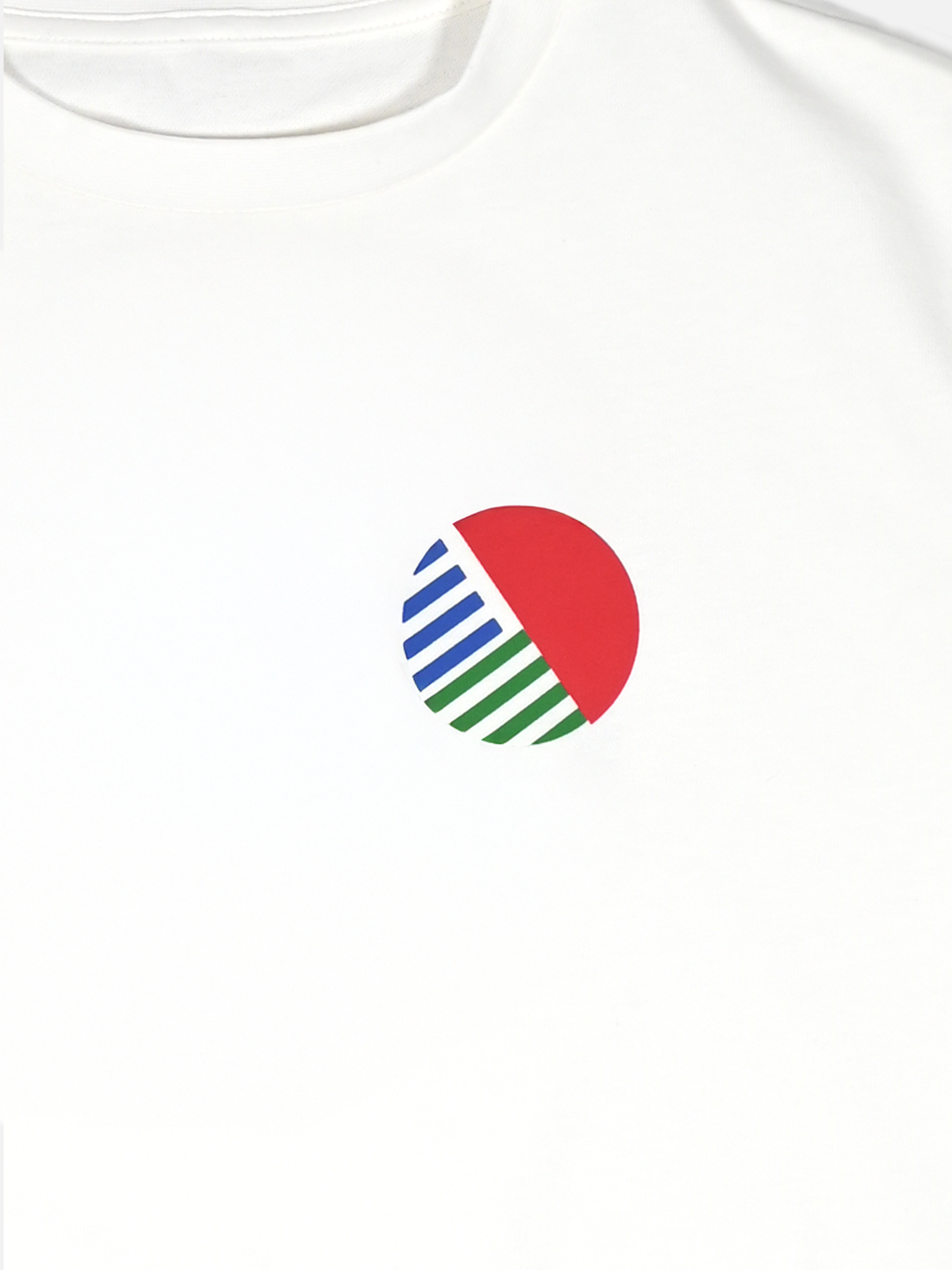 The Team Toshiba 90 Loose Fit T-shirt by La Machine Cycle Club is a white heavy cotton shirt with a small cycling jersey-inspired chest graphic—a red semicircle on the upper right and blue and green diagonal stripes on the lower left.