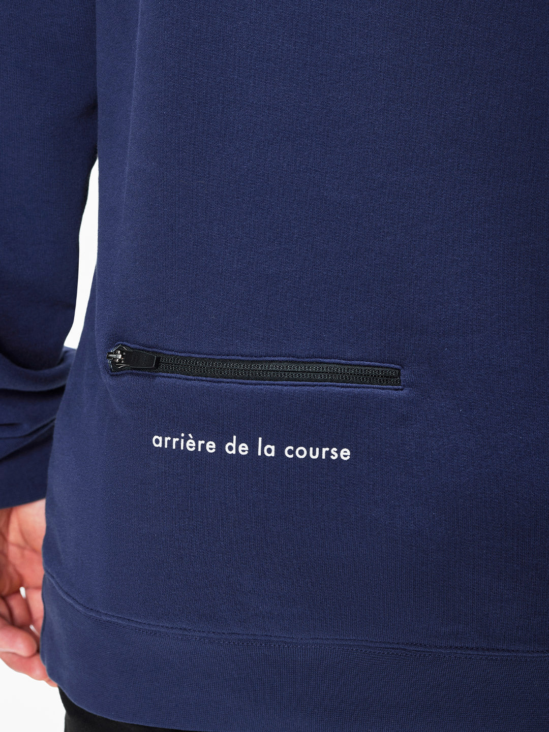 Close-up of the Tête de la Course mens sweatshirt by La Machine Cycle Club, in navy blue 100% cotton, with a horizontal zippered pocket and arrière de la course in white below the zipper.