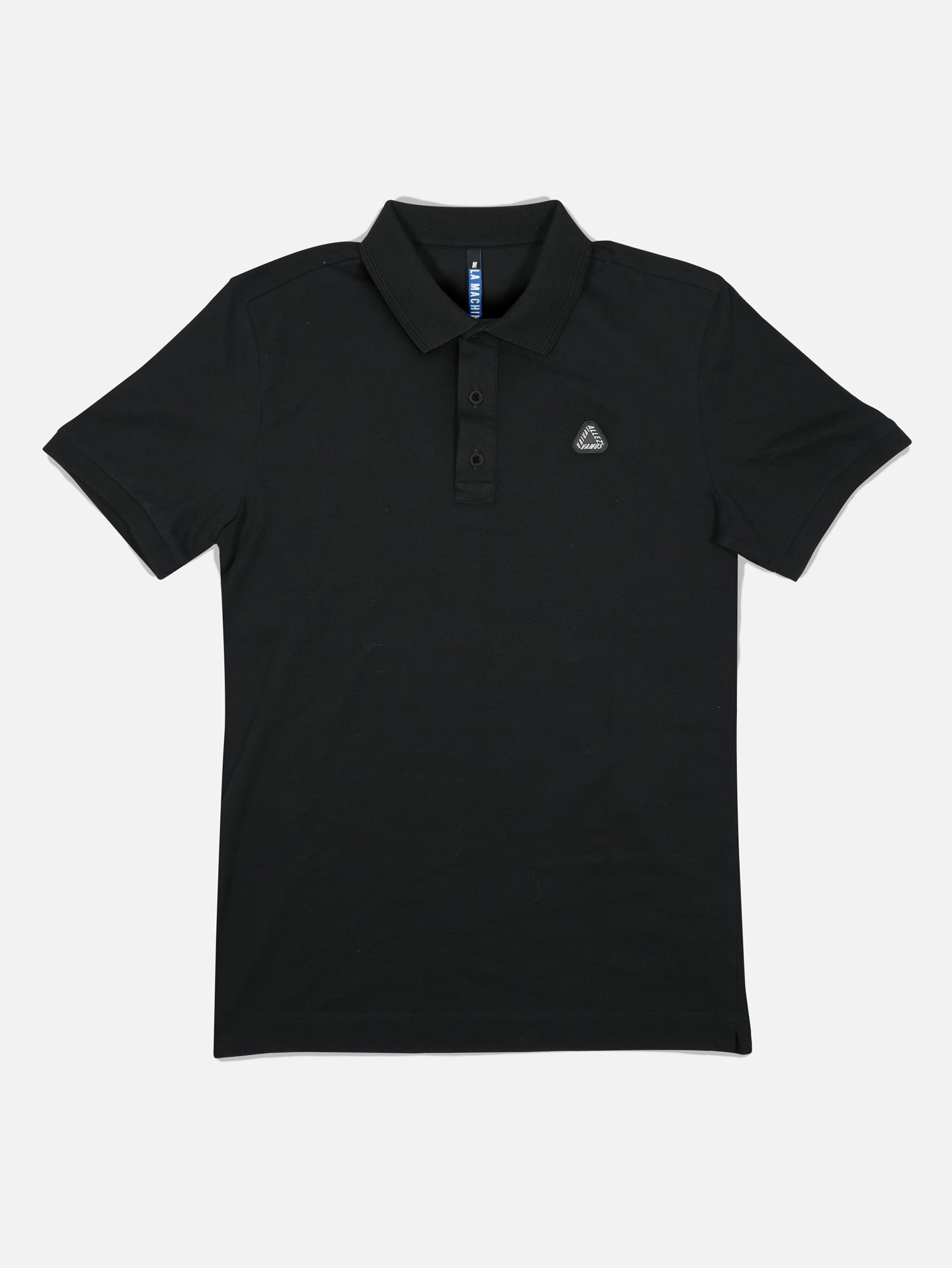 The Vai Allez Vamos Polo Shirt by La Machine Cycle Club is a unisex black short-sleeve polo with a collar, three buttons, and an embroidered left chest logo, shown laid flat on a white background.