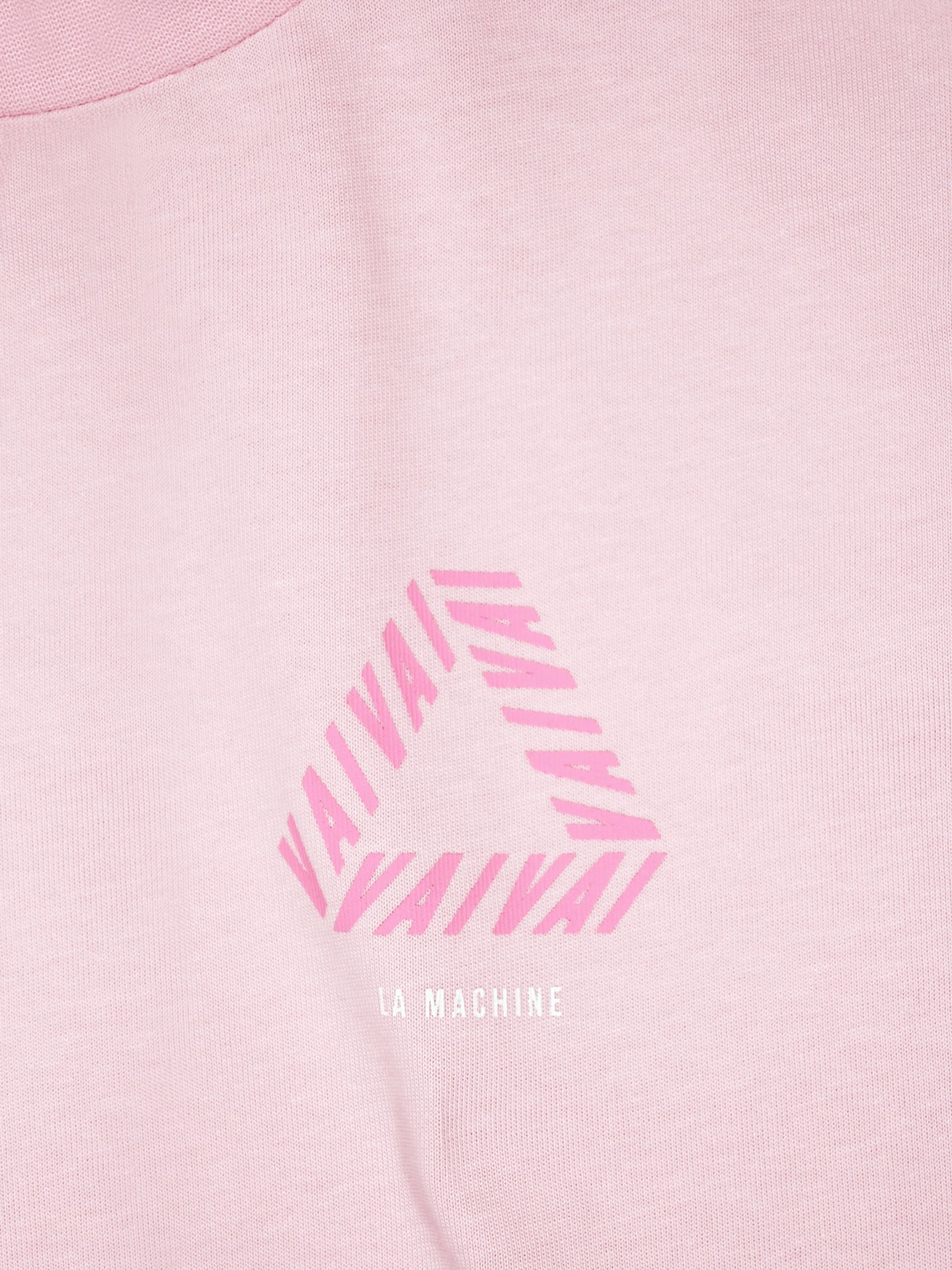 The Vai Vai - Loose Fit - Giro dItalia T-shirt by La Machine Cycle Club features pink fabric with an optical illusion triangle of repeated VAI in pink and LA MACHINE in small white text below, inspired by the Giro d’Italia’s vibrant energy.