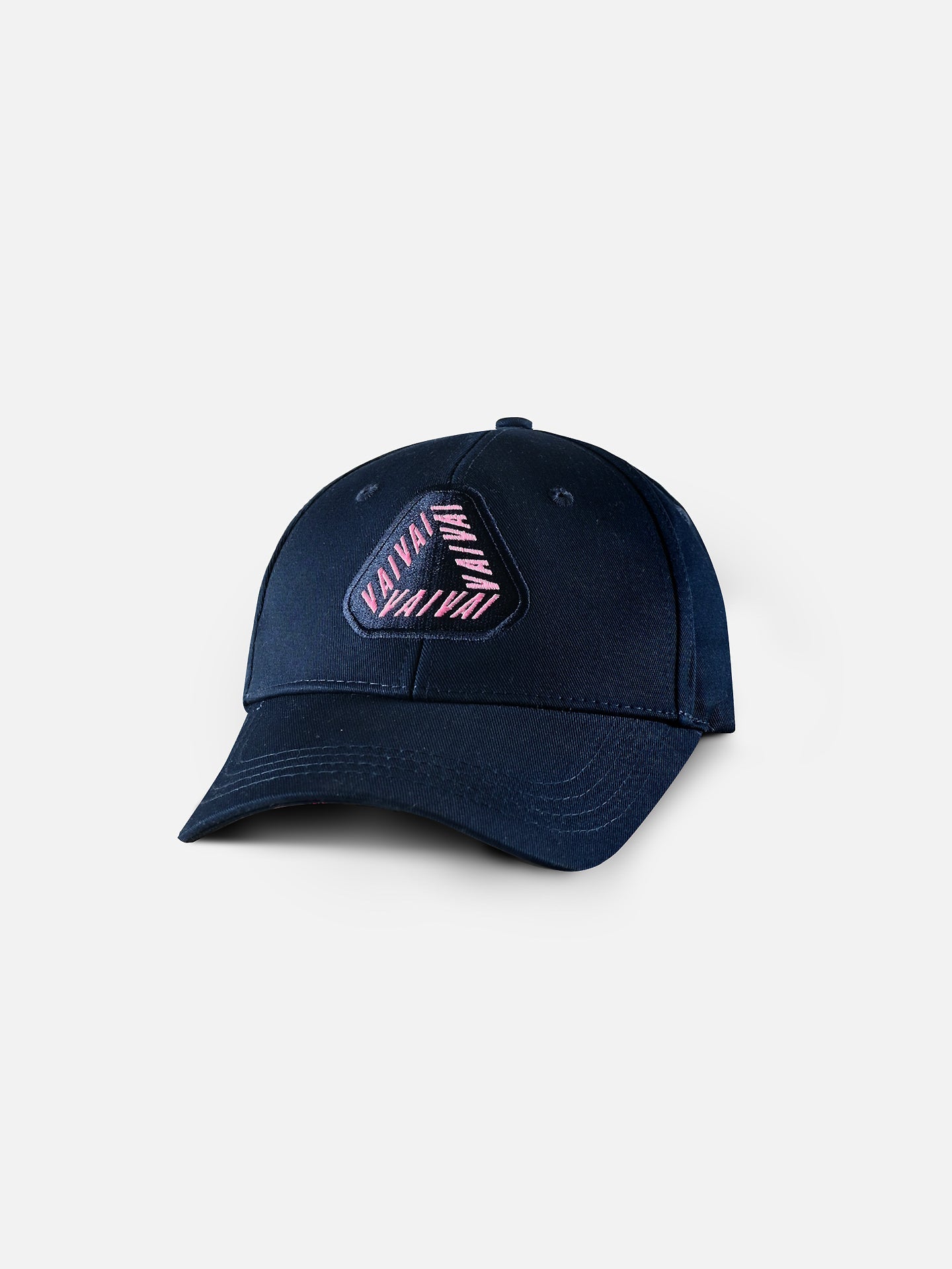 The Vai Vai - Casual Cap by La Machine Cycle Club features a dark blue design with a geometric embroidered patch of angled pink and white stripes and VANA on the front—ideal for fans of classic cycling cap style.