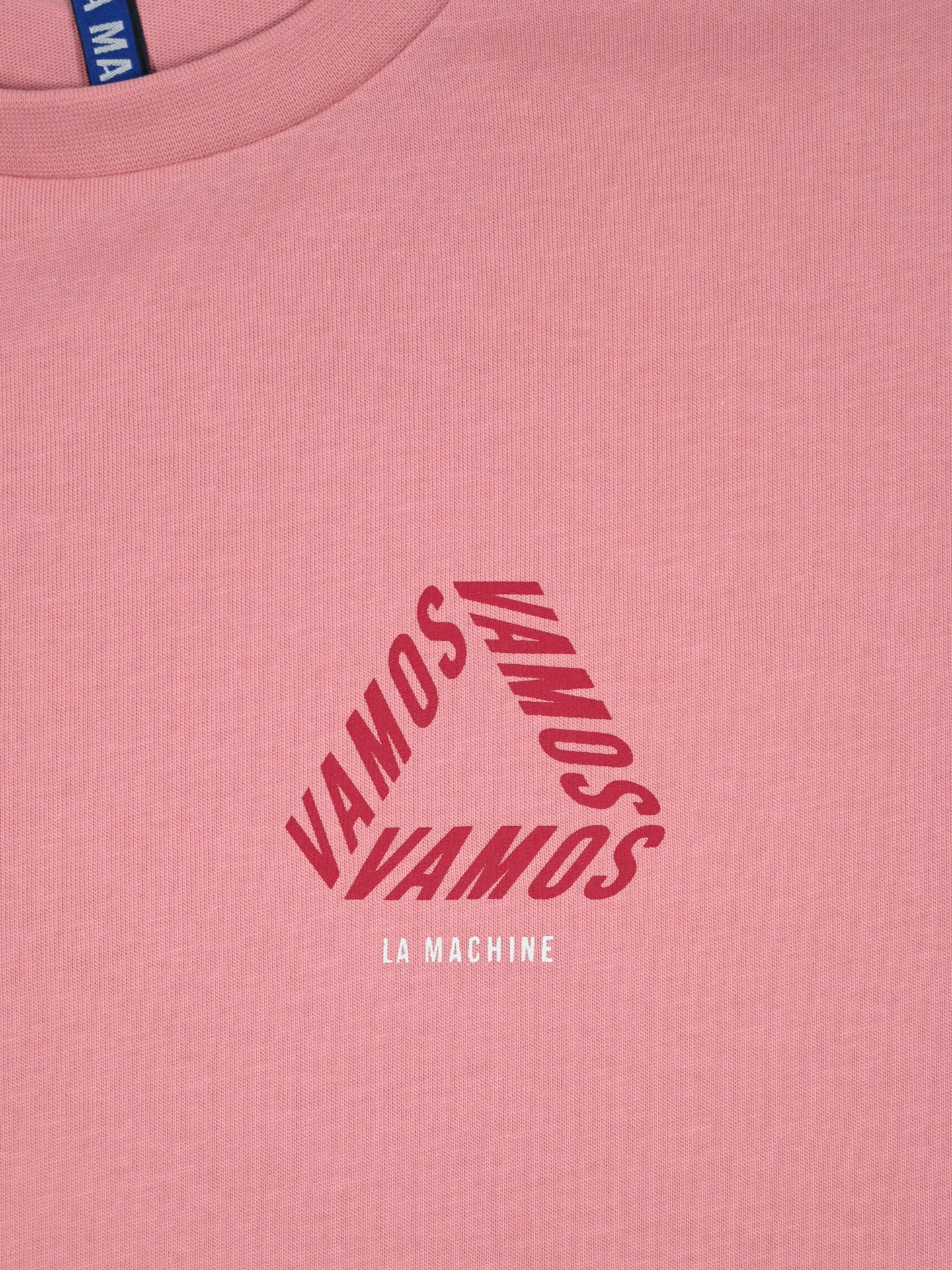 A close-up of the Vamos - Loose Fit - Vuelta a España T-shirt by La Machine Cycle Club, featuring VAMOS repeated in a triangle and La Machine below—a tribute to Spanish cycling and the Vuelta a España.