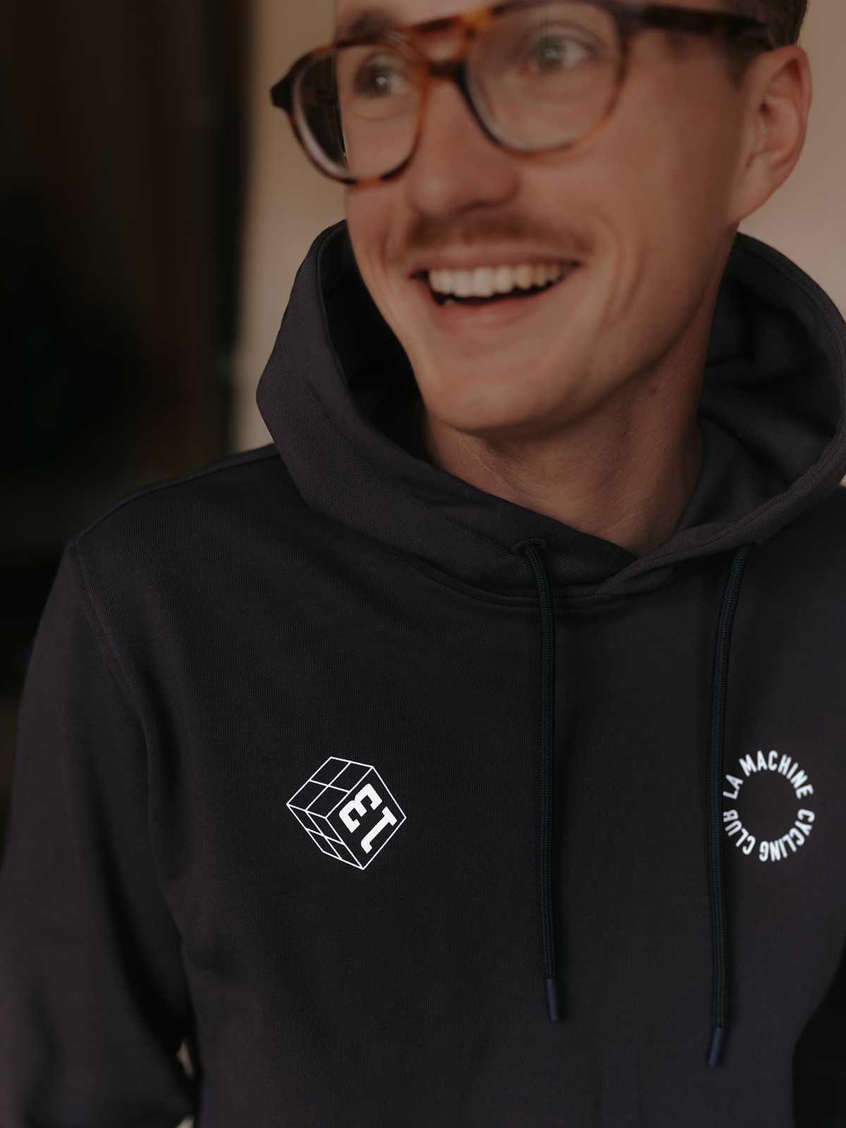 The Grand Tours Hoodie in dark navy blue by La Machine, folded.