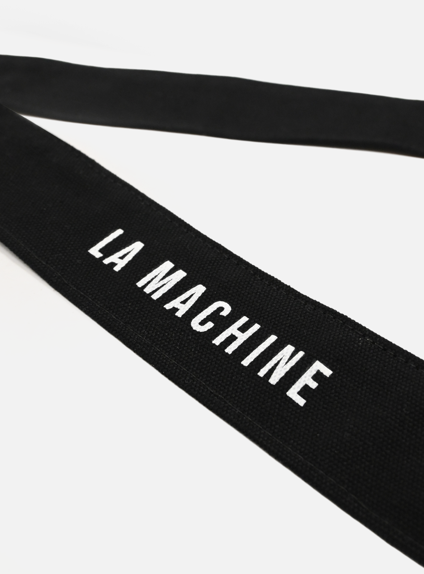 A close-up of the La Machine - Musette - Black by La Machine Cycle Club shows its black fabric strap with LA MACHINE in bold white letters, set against a plain white background.