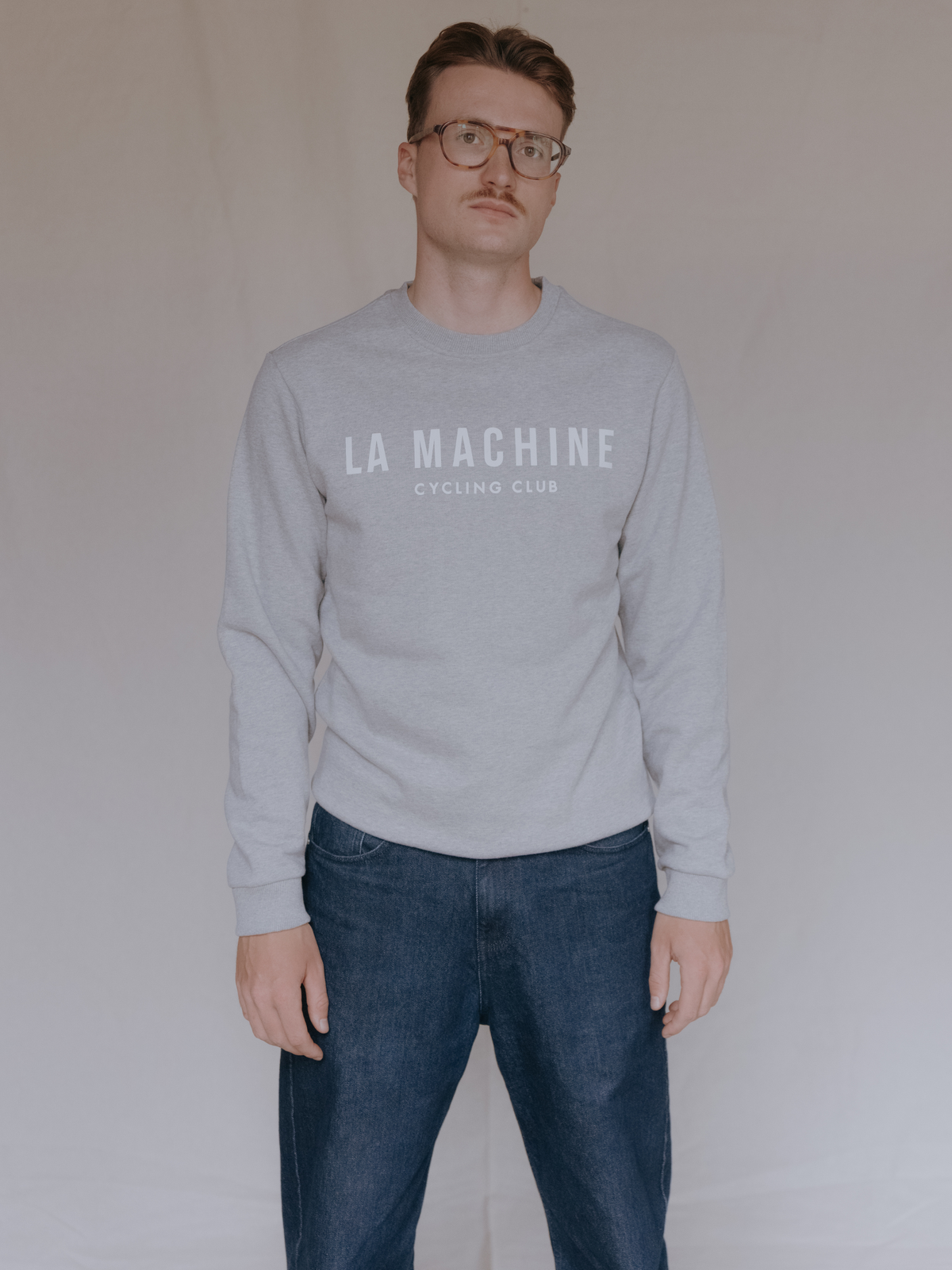 A model wearing the La Machine Club Line Sweatshirt in grey melange.