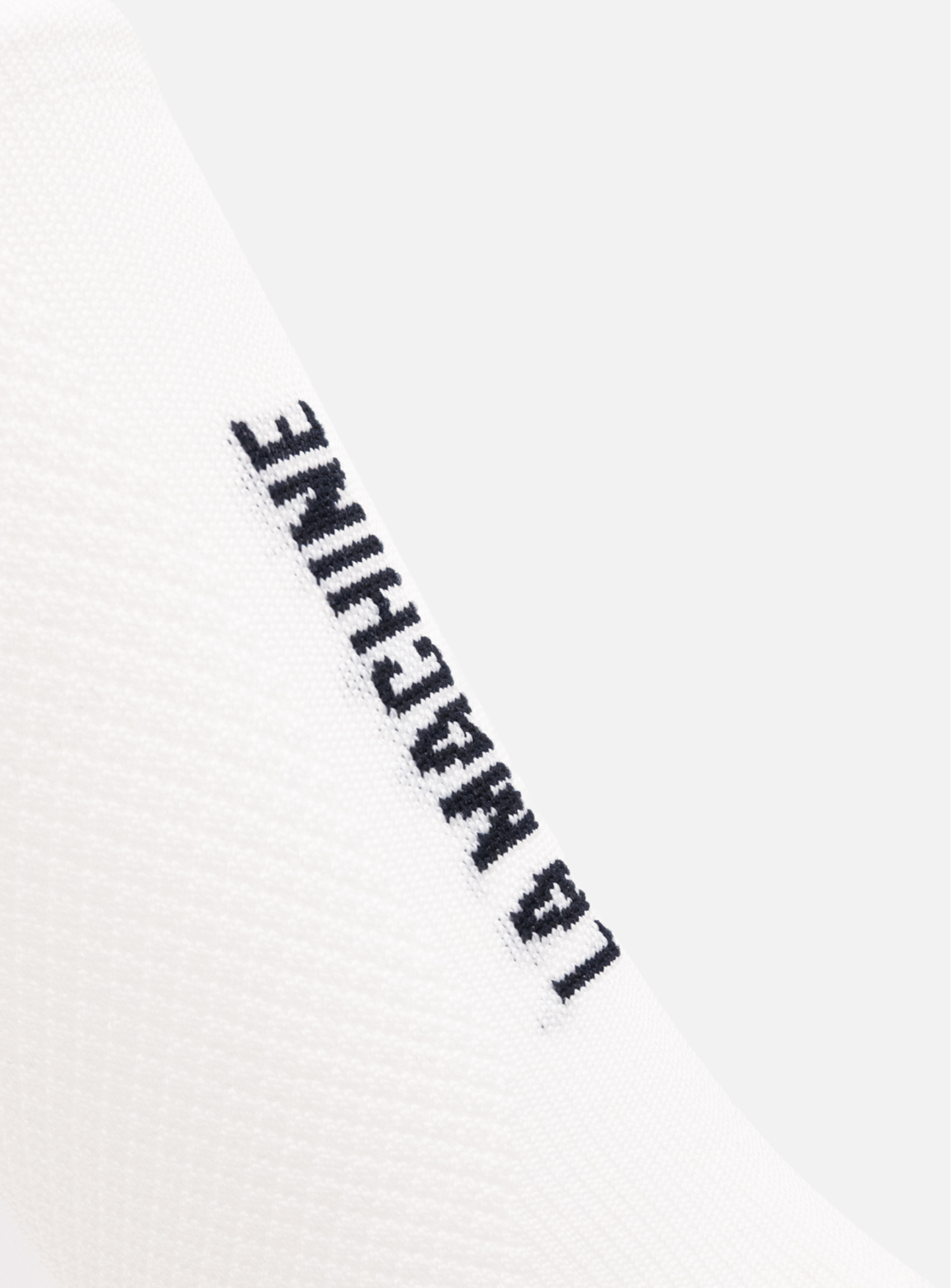 Close-up of La Machine Logo - Cycling Socks in white by La Machine Cycle Club, featuring LA MACHINE text in black capitals running vertically. Unisex design suits any style.