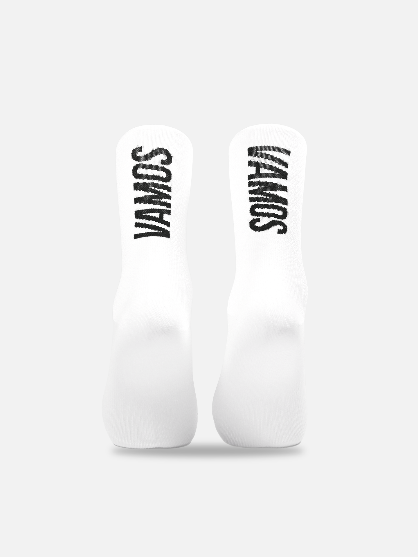 The La Machine Cycle Club Vamos - Cycling Socks, shown upright side by side on a plain background, are all-white with VAMOS in bold black lettering and feature a seamless toe for maximum comfort.