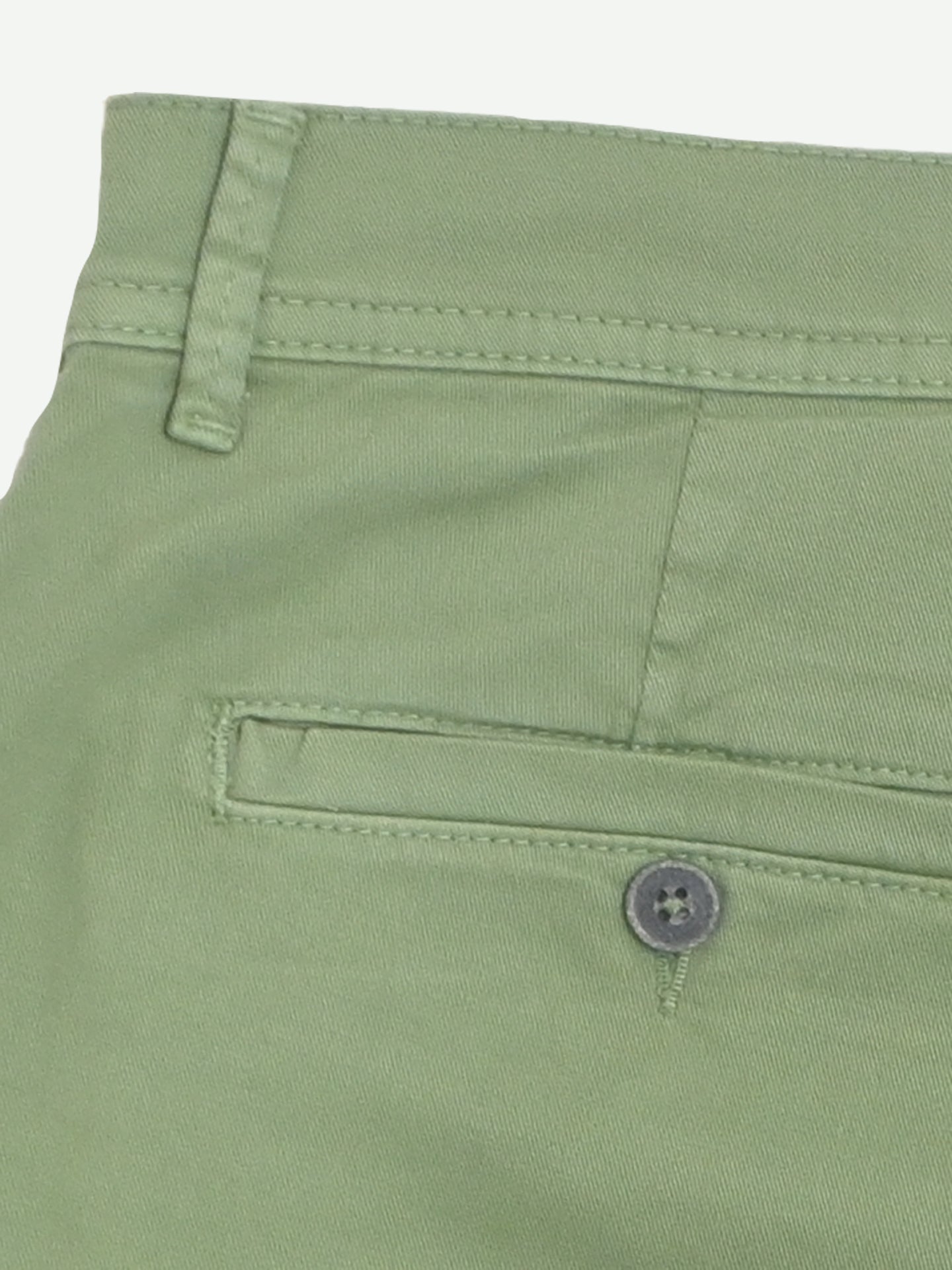 Close-up of the back pocket on La Machine Cycle Clubs Grand Tours - Rest Day Bermuda in Dusty Green, showing a single welt pocket with button closure and belt loop—ideal for off-bike comfort with their relaxed, semi-tailored fit.