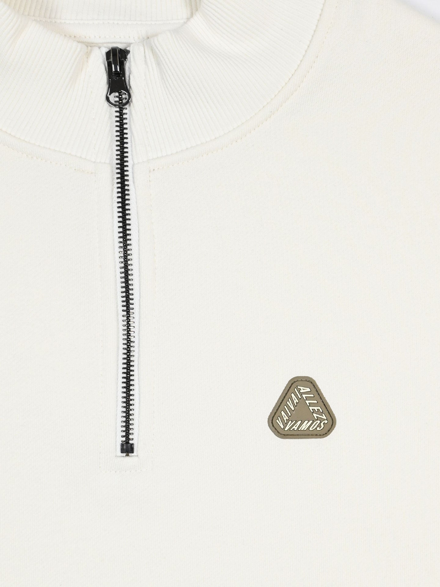 Close-up of the Vai Allez Vamos half-zip sweatshirt by La Machine Cycle Club, in thick cotton with a vertical silver zipper and a small triangular badge on the left chest reading VIVA ALLES MAKOS.