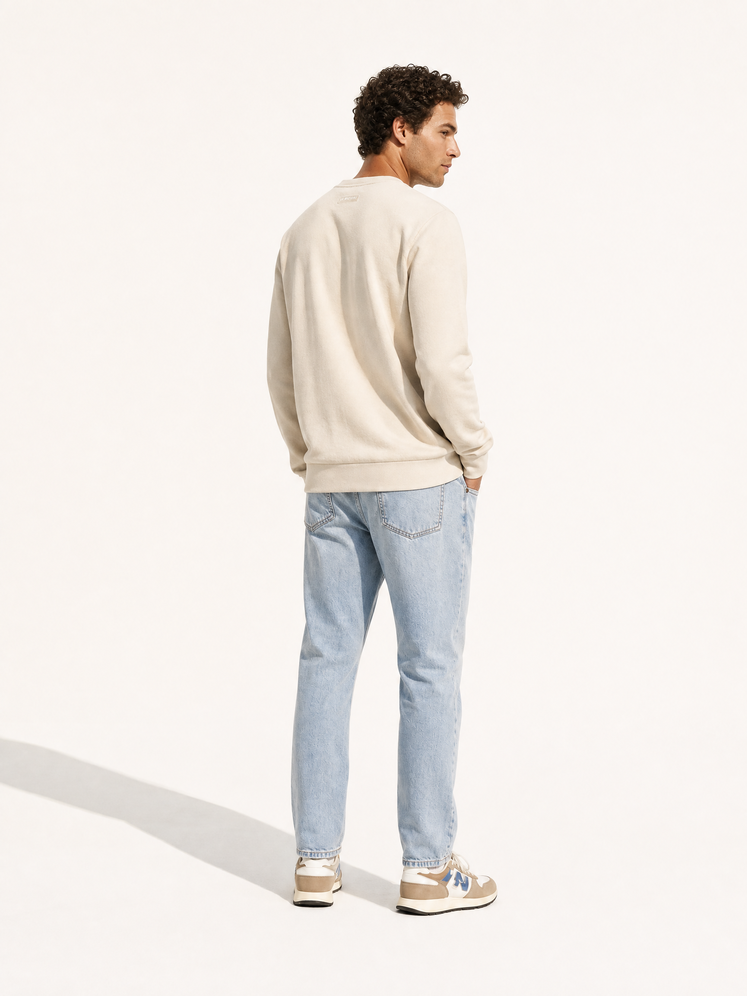 A model wearing the G.O.A.T. - Sweatshirt - Oyster Grey by La Machine Cycle Club.