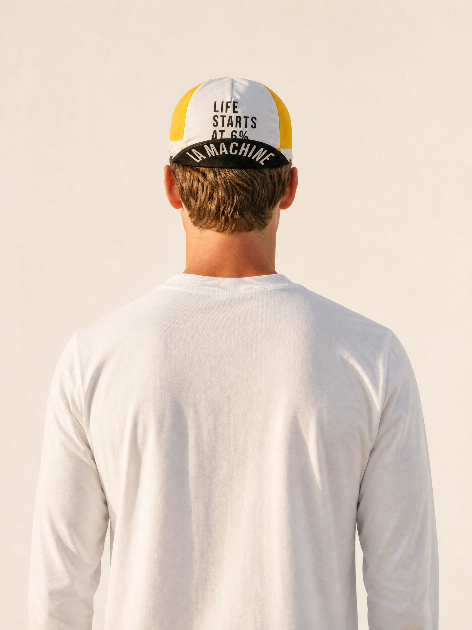 A model wearing the Life starts at 6% - Cycling Cap by La Machine Cycle Club.