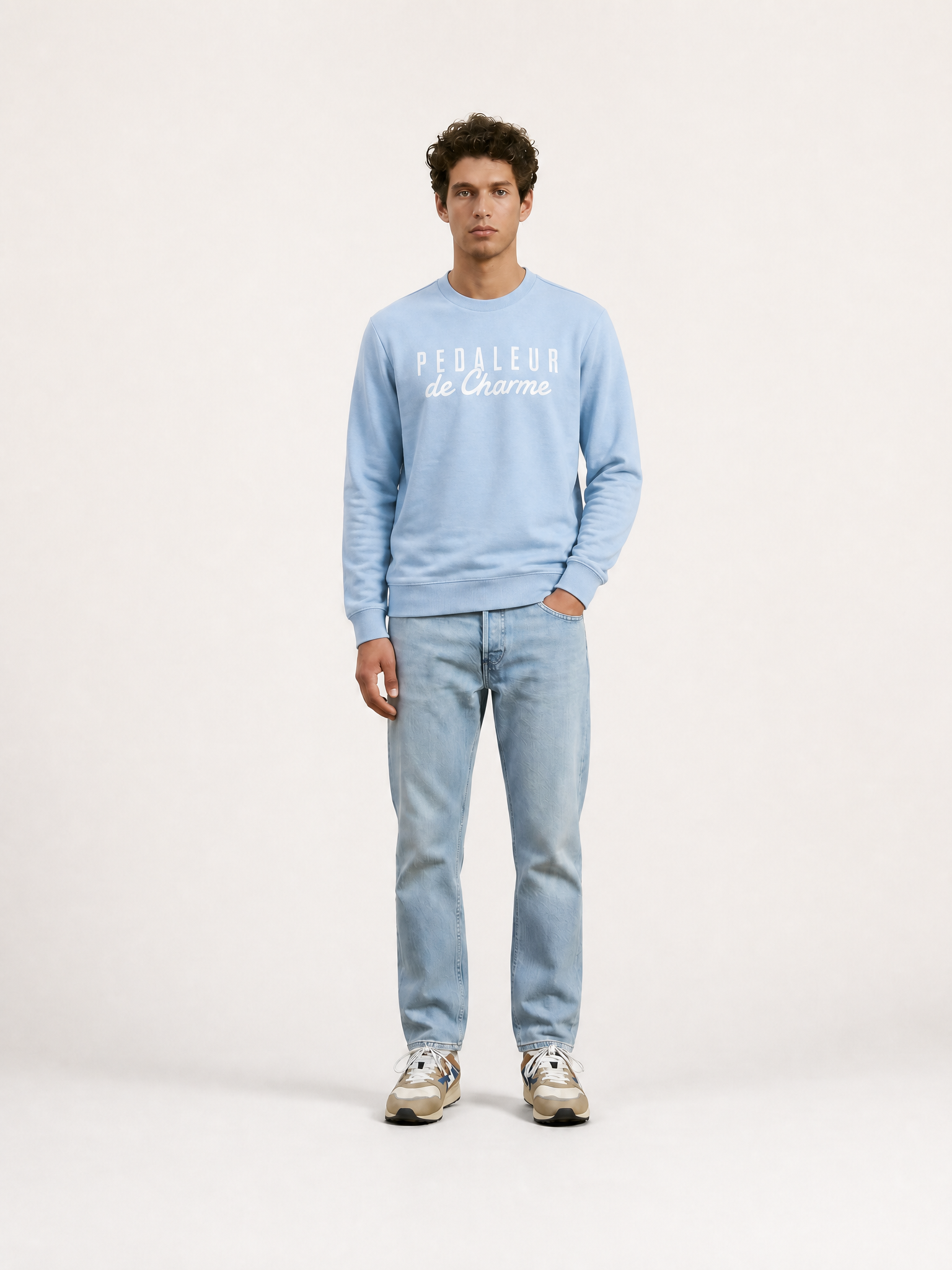 A model wearing the Pedaleur de Charme - Sweatshirt - Light Blue by La Machine Cycle Club.