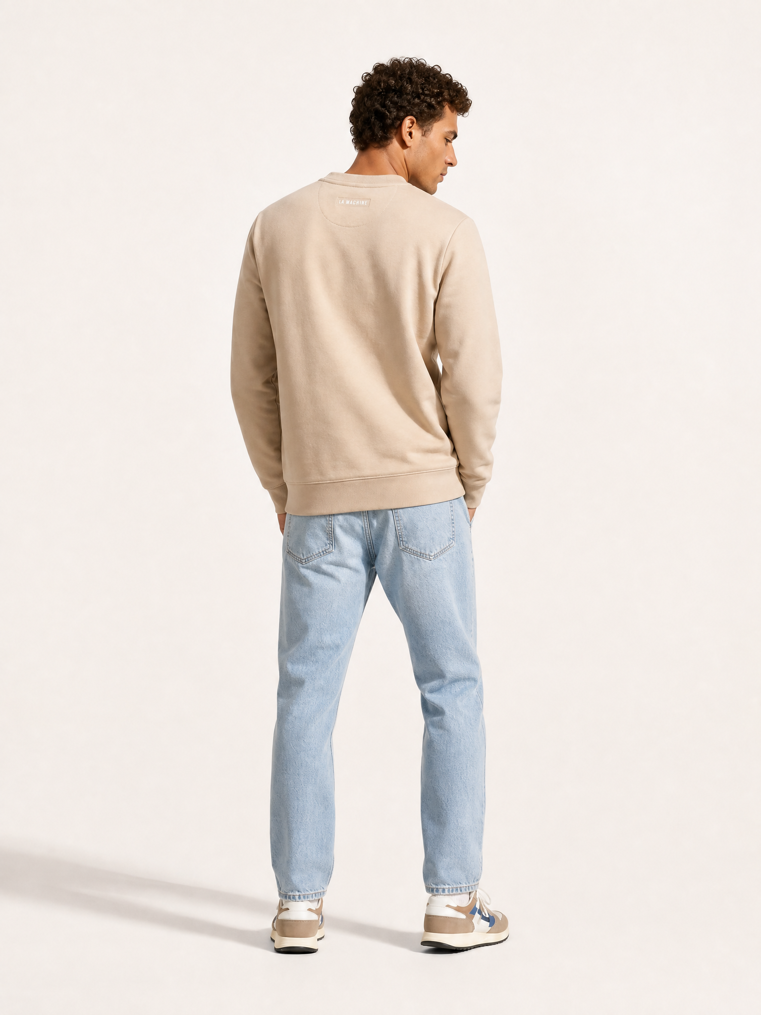 A model wearing the Pedaleur de Charme - Sweatshirt - Sand by La Machine Cycle Club.