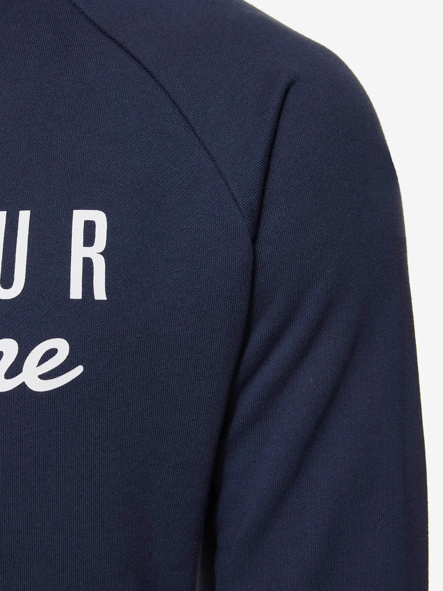 Close-up of the upper sleeve and chest of the La Machine Cycle Clubs Pedaleur de Charme - Sweatshirt in navy, featuring partial white Giro d’Italia winner-inspired text on the front.