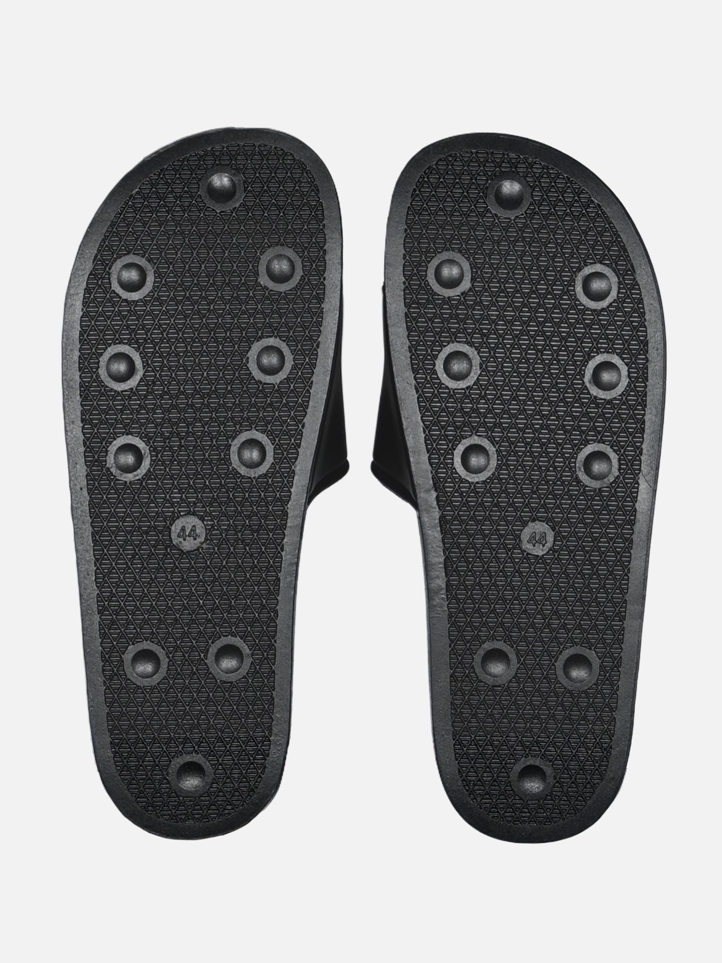 The La Machine Logo Slides/Slippers by La Machine Cycle Club feature black soles with textured patterns and circular rubber grips—perfect as post-ride footwear or comfortable slippers after a long day cycling.