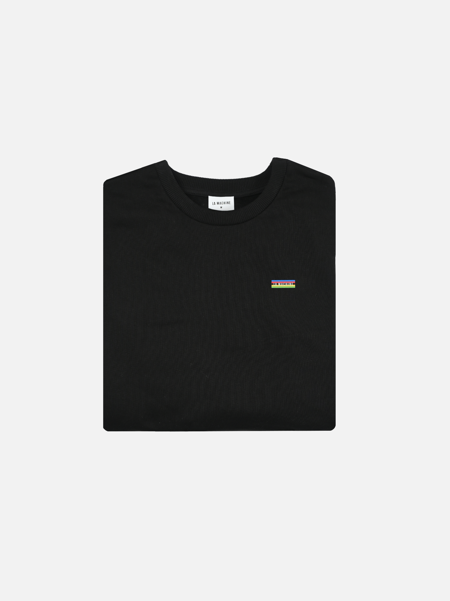 The Earn the Stripes Jet Black sweatshirt by La Machine Cycle Club is displayed neatly folded, featuring a 100% cotton build and a small yellow, green, and blue striped rectangular logo on the left chest against a plain white background.