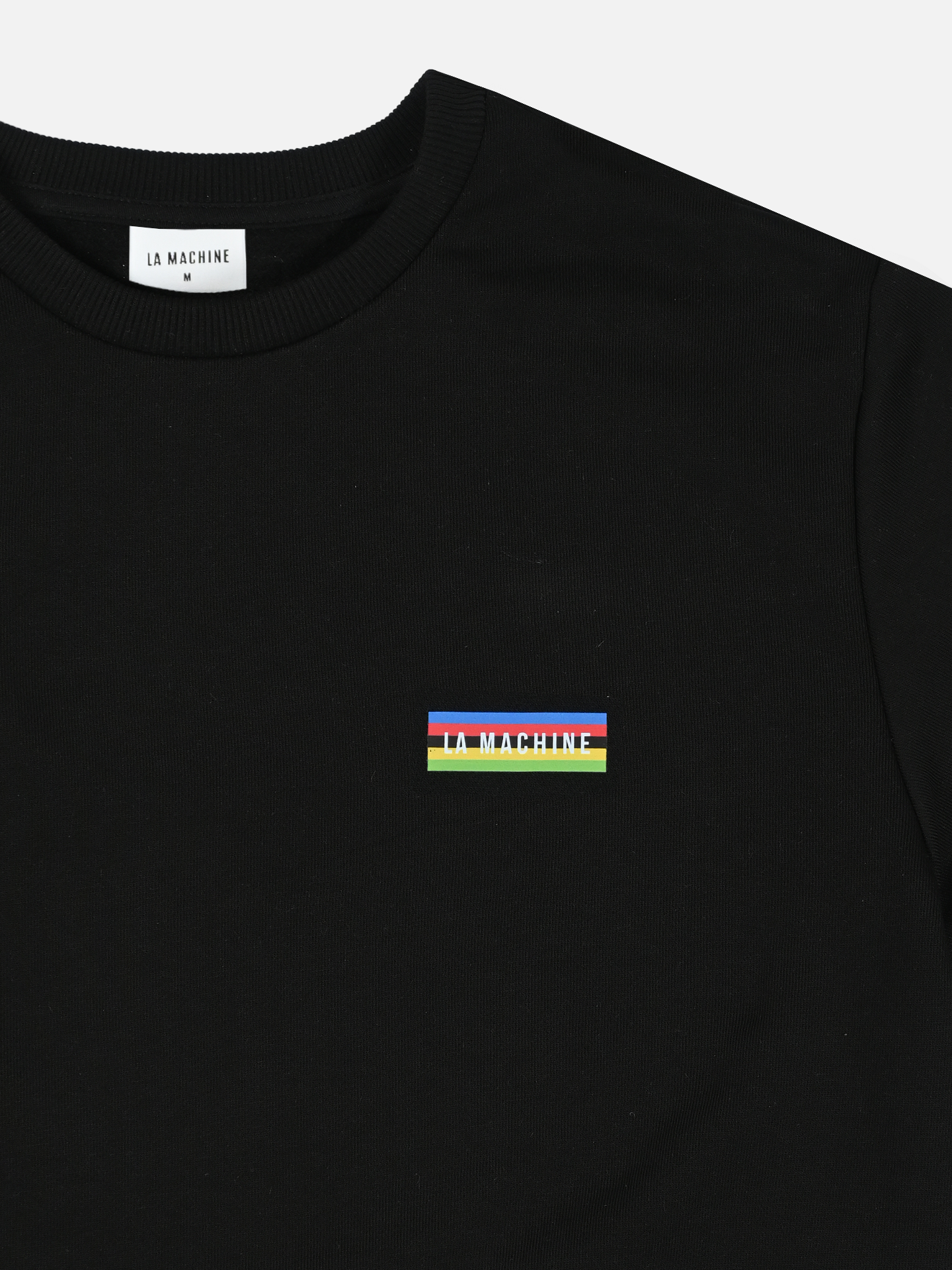 The Earn the Stripes - Sweatshirt - Jet Black by La Machine Cycle Club is a black crewneck made from 100% cotton, featuring a small multicolored rectangular La Machine patch on the chest and a neck label with size K.