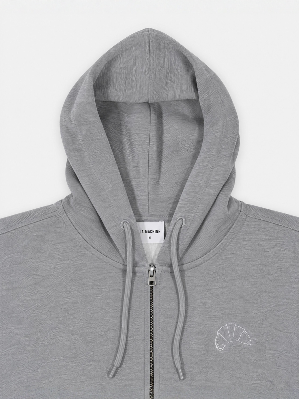 A model wearing the I Brake for Croissants zipped hoodie in melange grey.