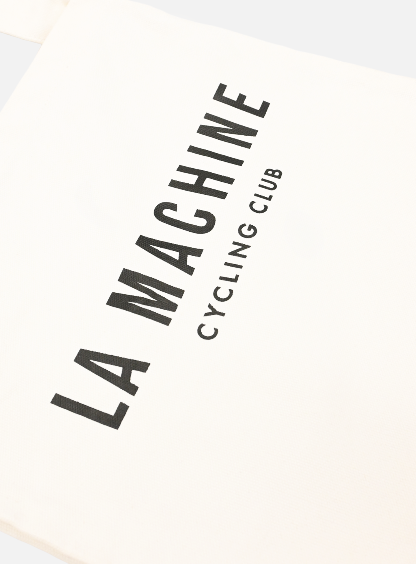 The La Machine Cycle Club Musette in white features bold black La Machine text with CYCLING CLUB written vertically underneath.