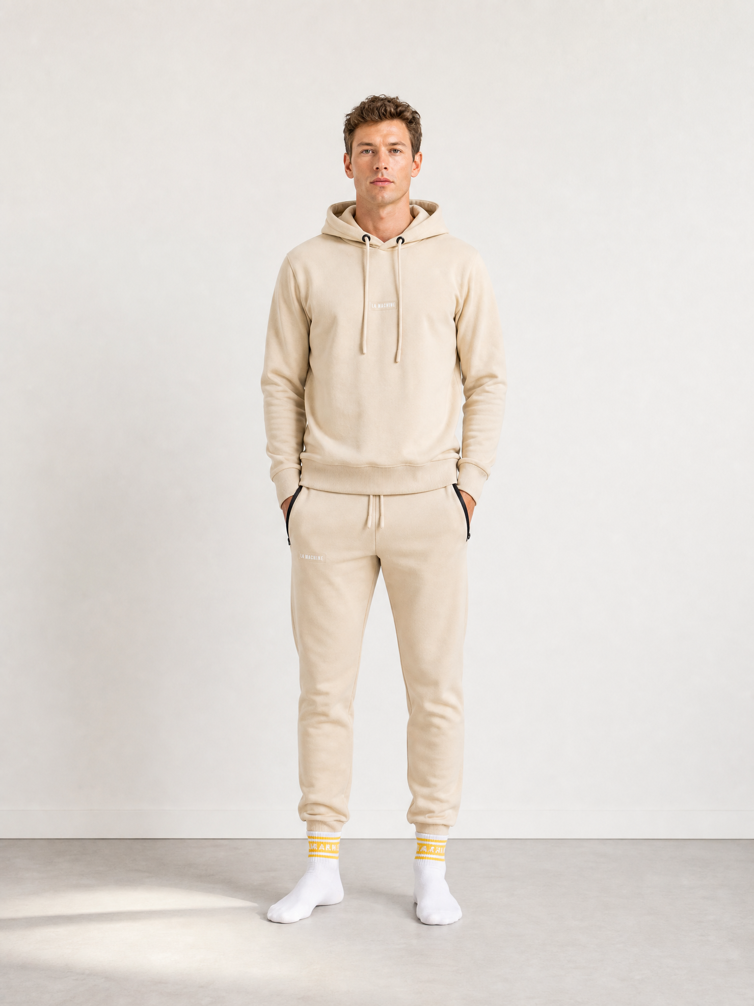 A model wearing the Beyond the bike - Hoodie + Sweatpants - Gravel Grey - Bundle by La Machine Cycle Club.