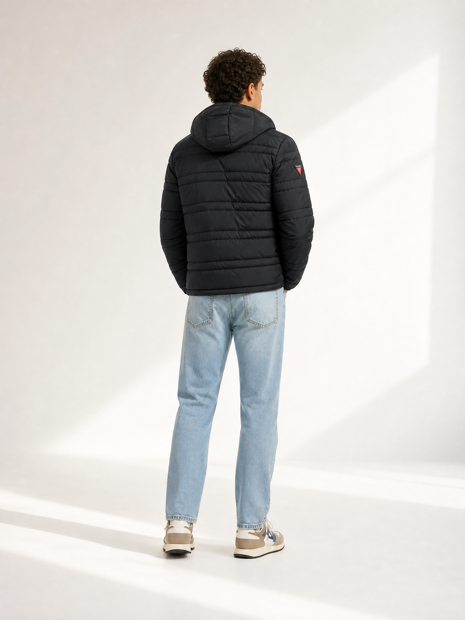 A model wearing the Beyond the bike - Padded Jacket - Black by La Machine Cycle Club.