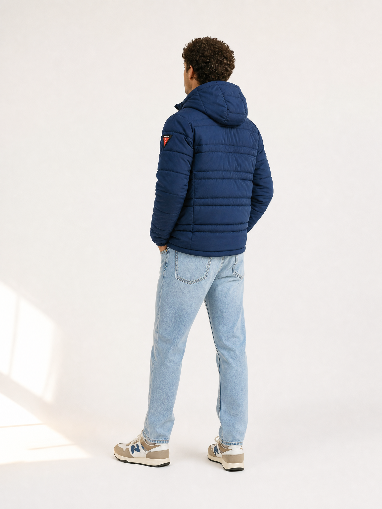 A model wearing the Beyond the bike - Padded Jacket - Blue by La Machine Cycle Club.
