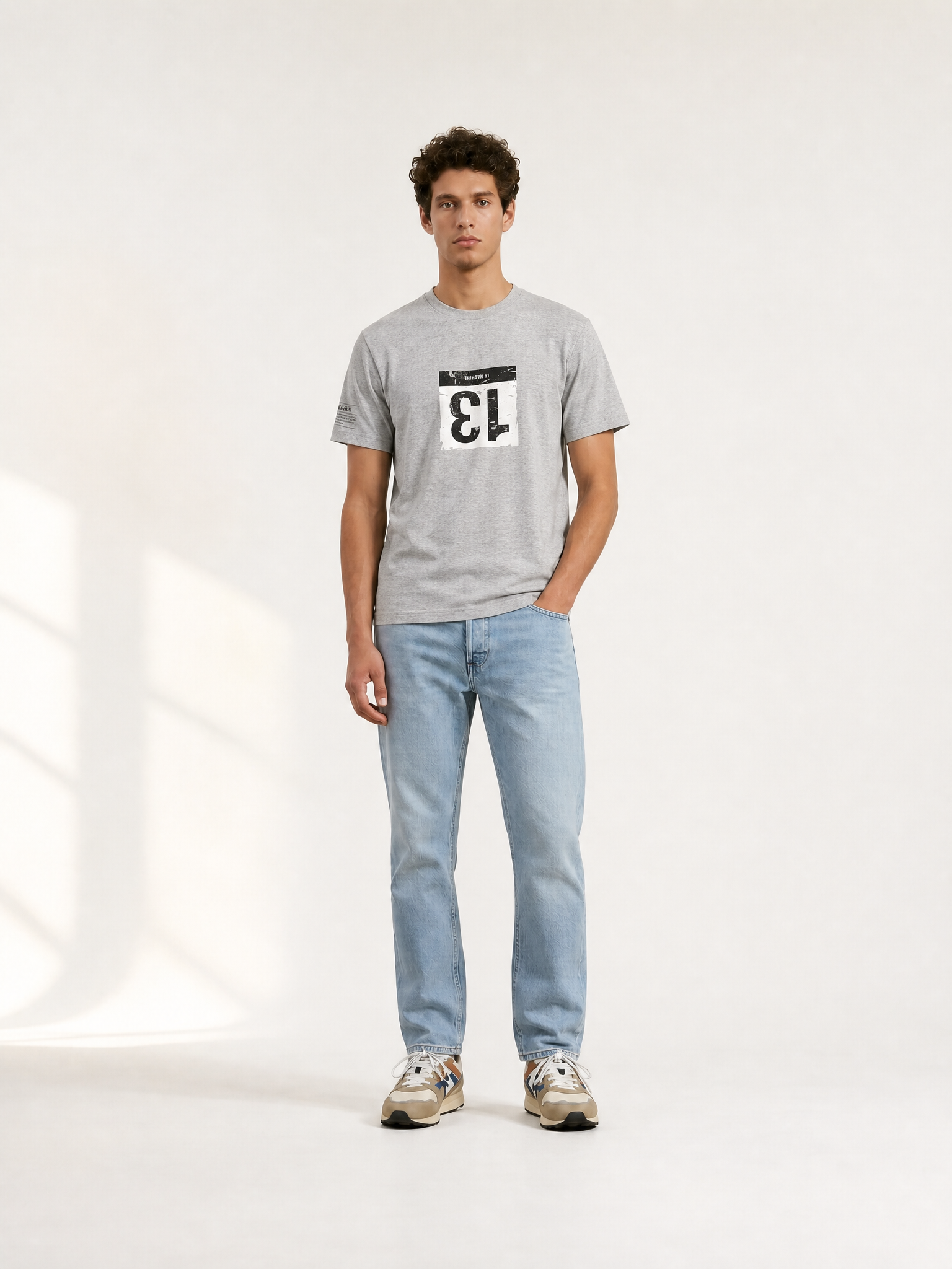 A model wearing the Bib Number 13 - T-shirt  - Melange Grey by La Machine Cycle Club.
