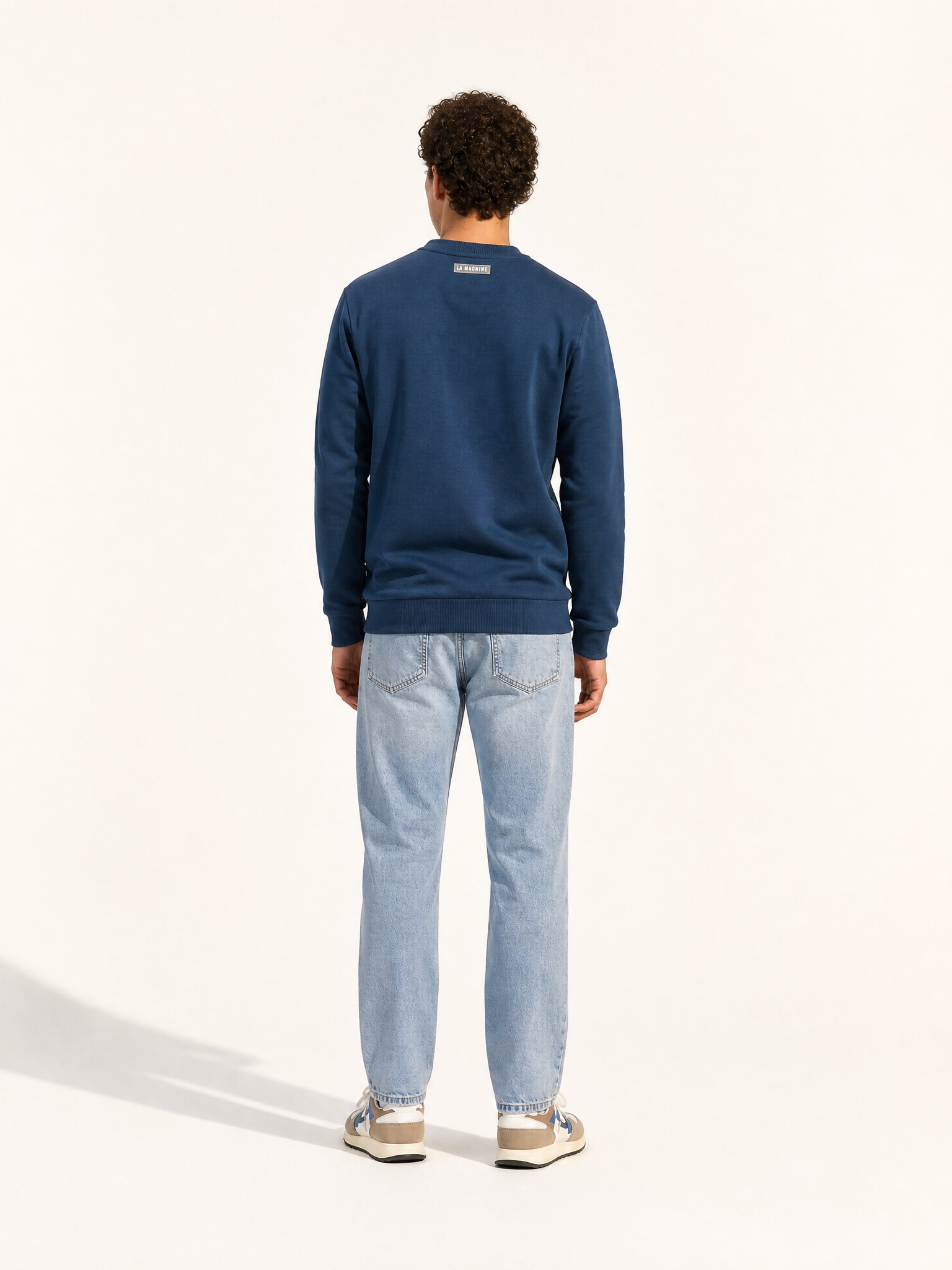 A model wearing the Coffee Ride Winners Club - Sweatshirt - Sailor Blue by La Machine Cycle Club.