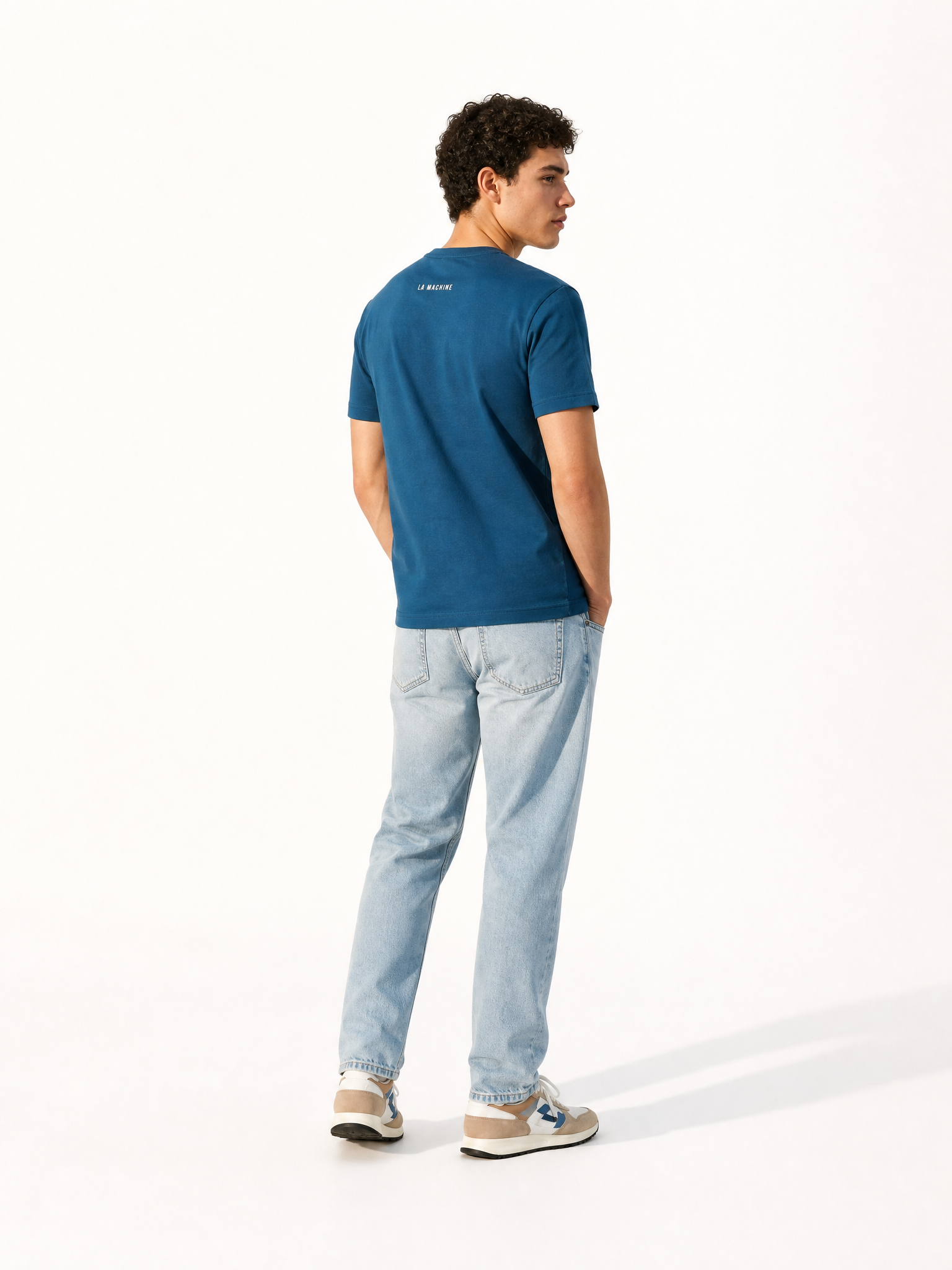 A model wearing the Coffee Ride Winners Club - T-shirt - Blue by La Machine Cycle Club.