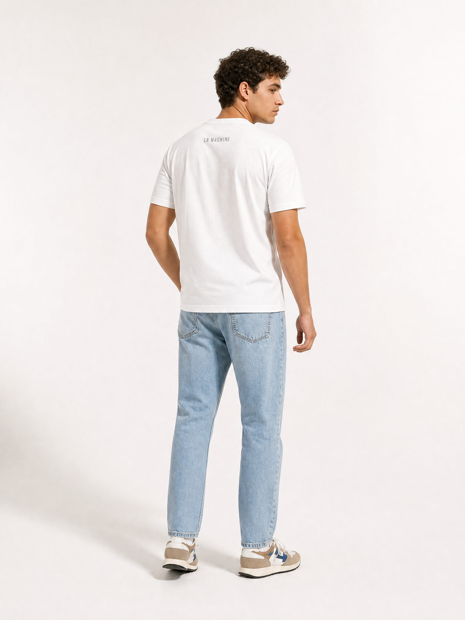 A model wearing the Coffee Ride Winners Club - T-shirt - White by La Machine Cycle Club.